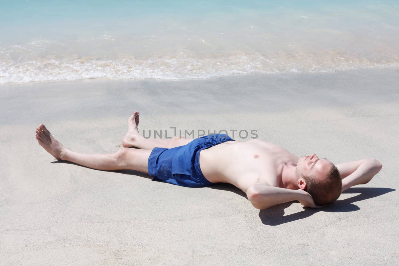 Man relaxing on beach by leeser
