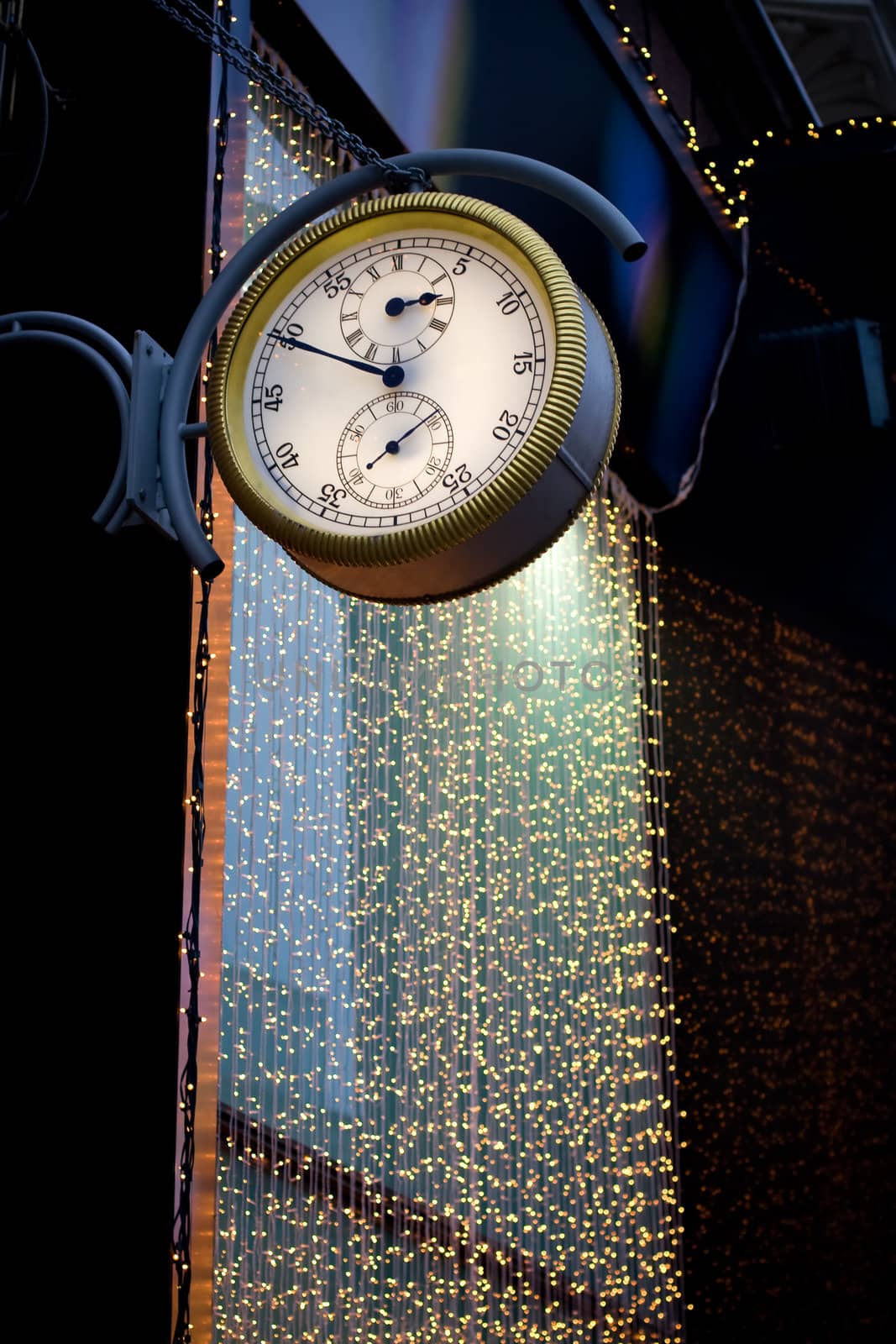 Street clock on a background of a garland