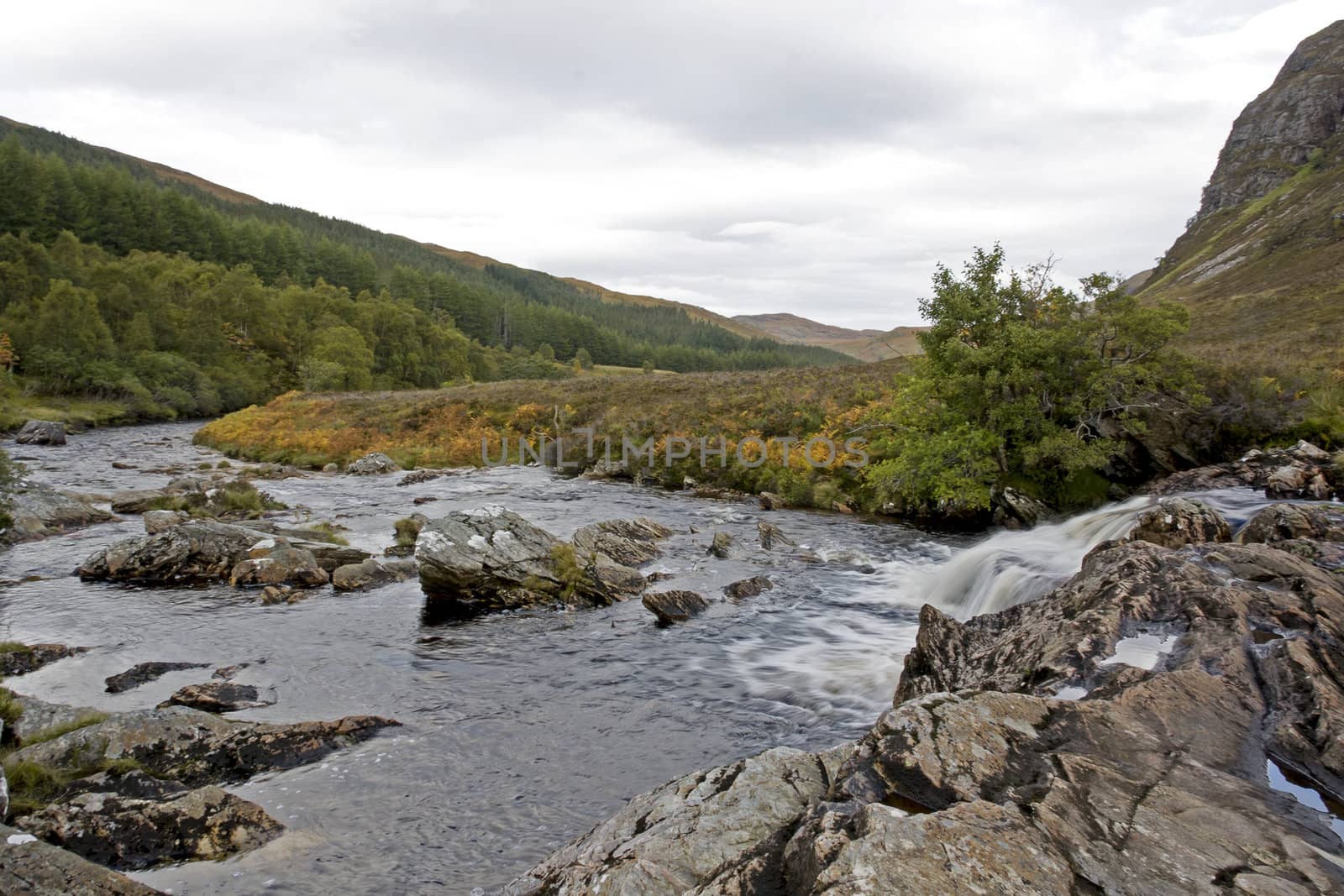 small river in scottish highlands flowing through heathland