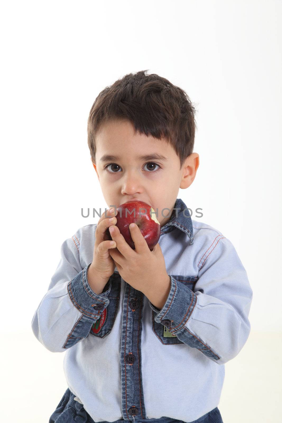 Child eating an apple on white background