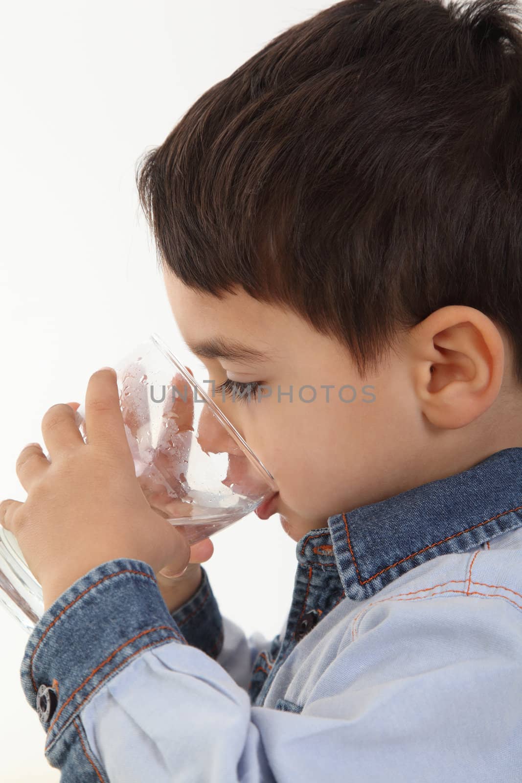 Handsome child drinking water in whie background