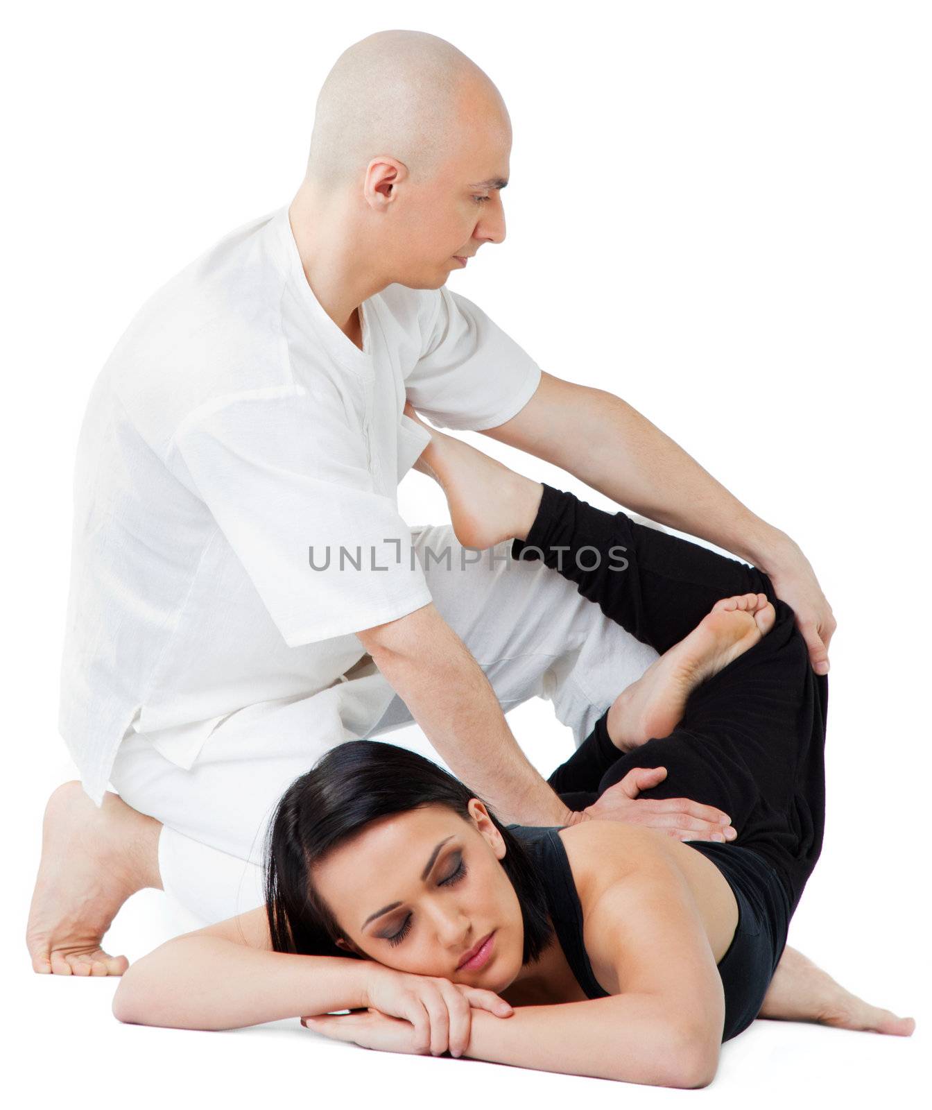 Young female receiving massage in thai position by therapist, eyes closed