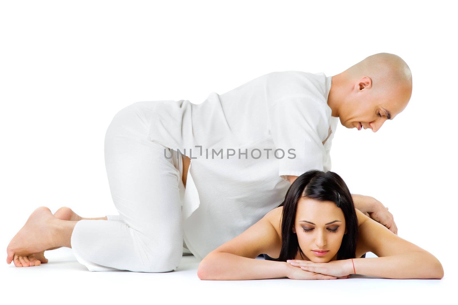 Beautiful woman lying and receiving traditional thai massage from therapist, eyes closed