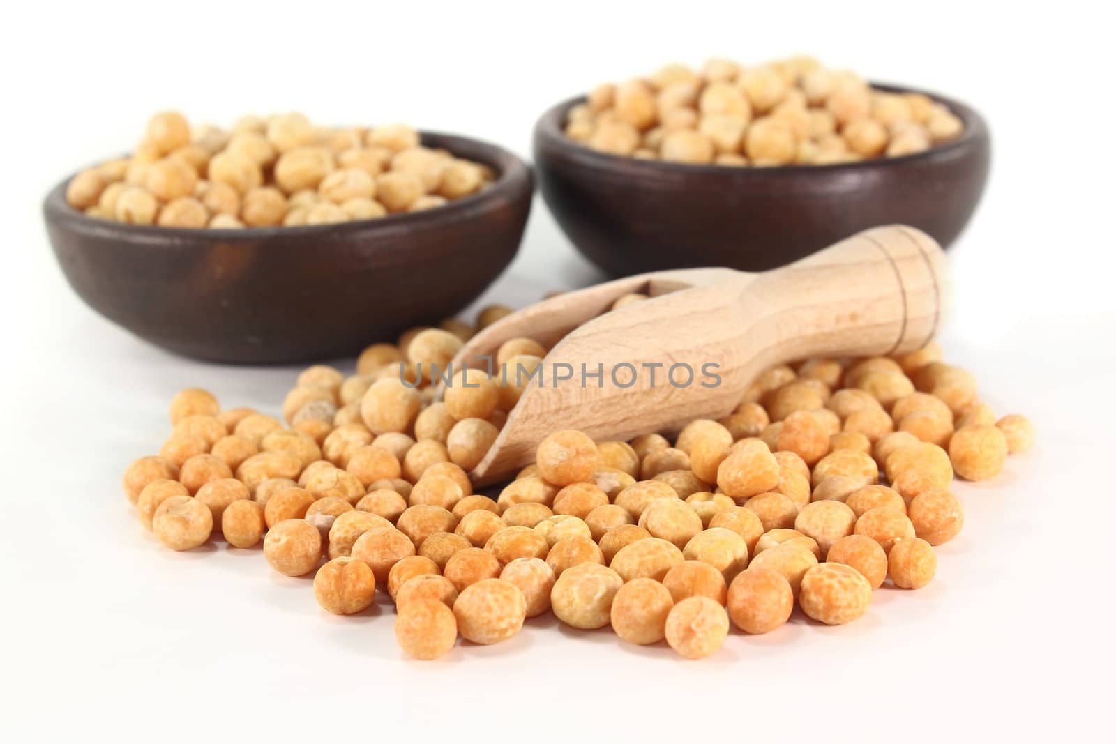 yellow peas and a shovel on a white background