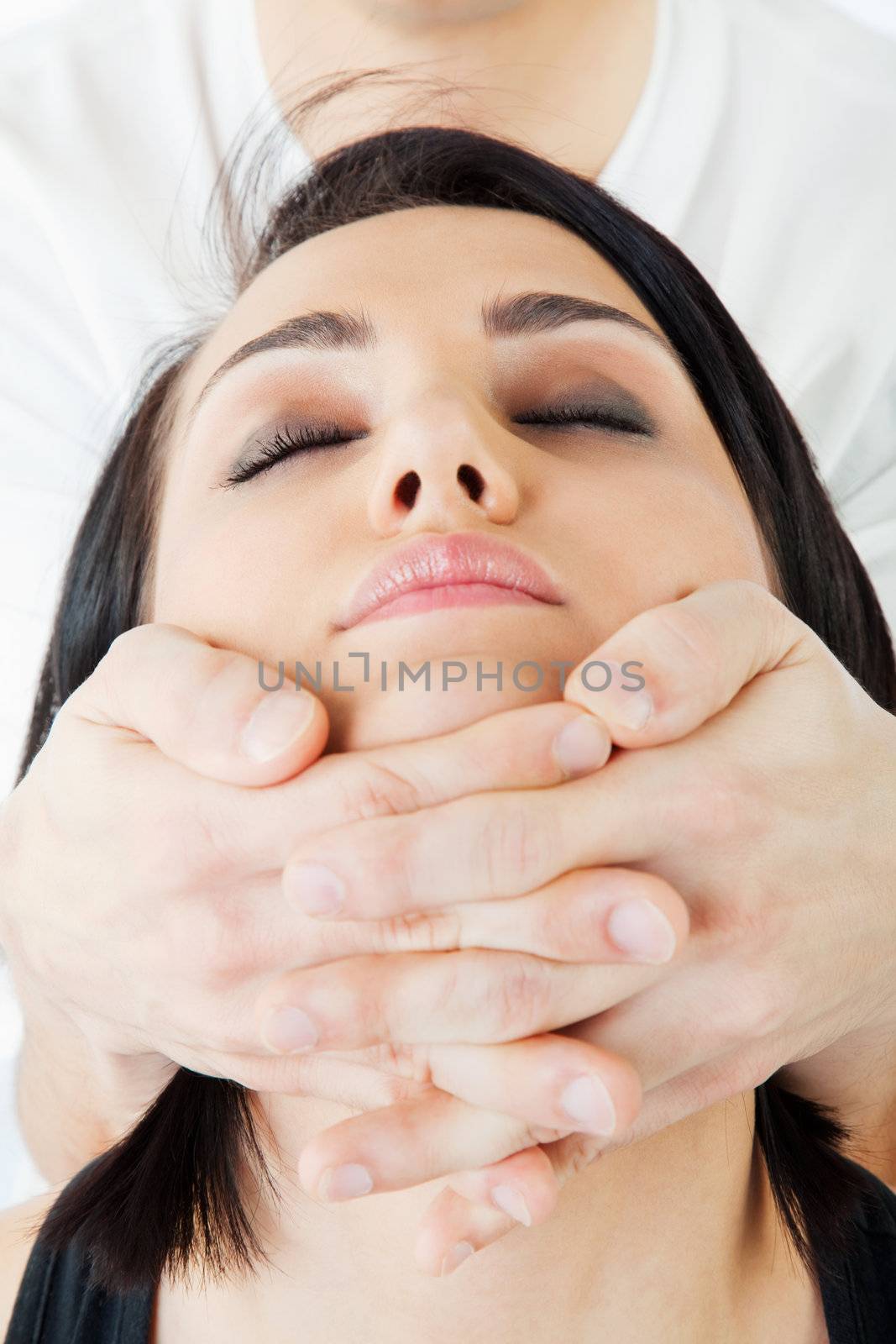 Close-up of young woman's face, receiving traditional thai neck massage
