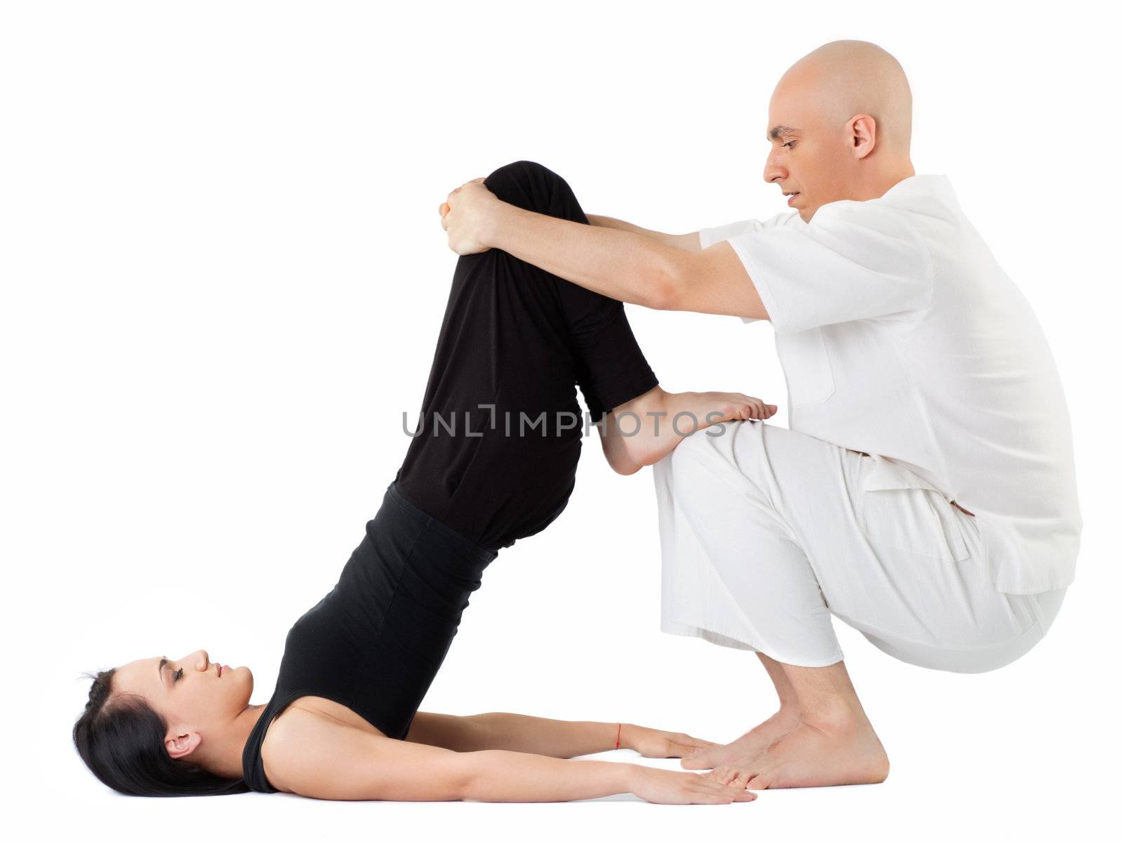 Young woman being stretched in thai position by therapist