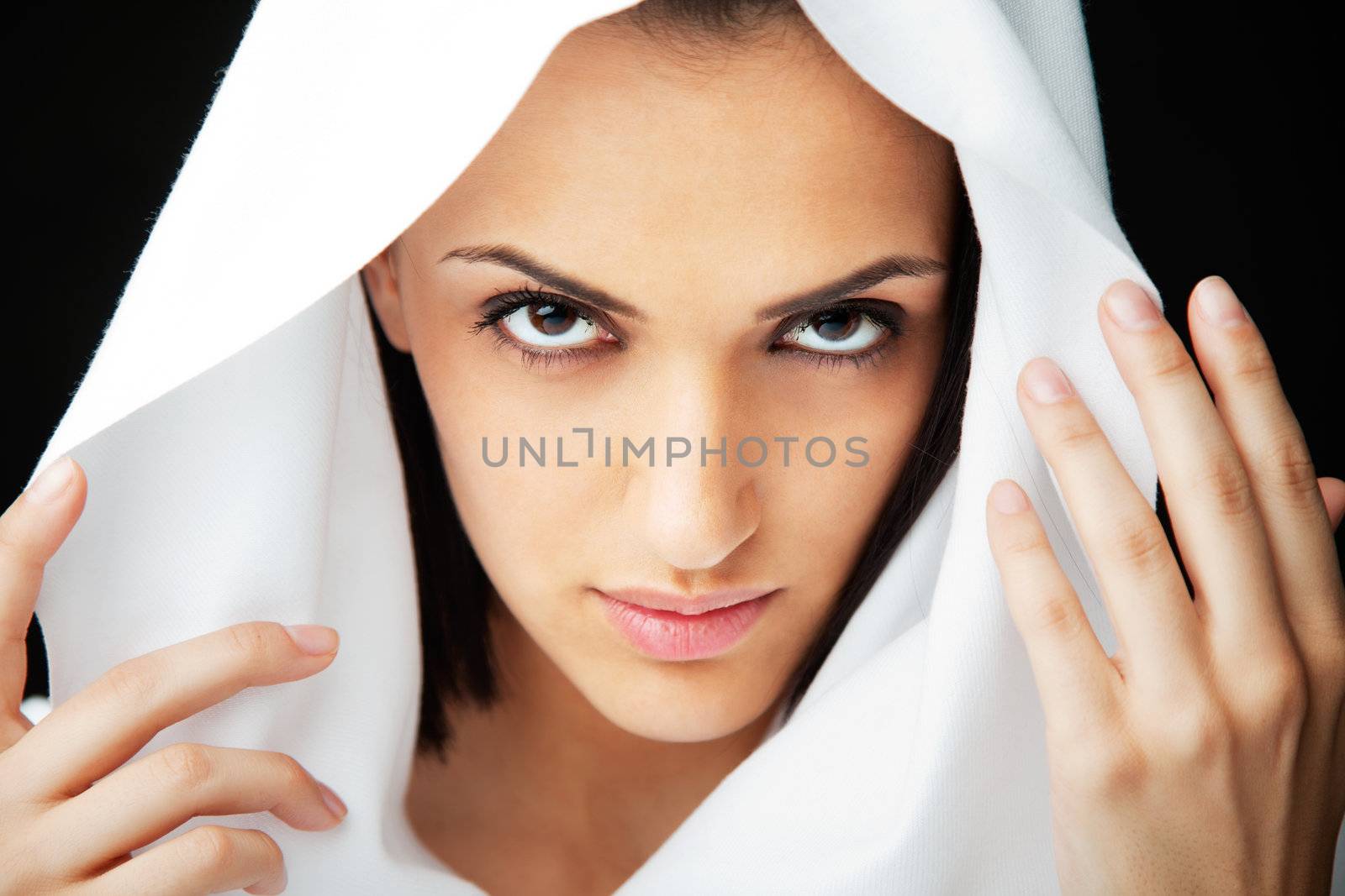 Close-up of beautiful woman holding white veil over head, looking at camera