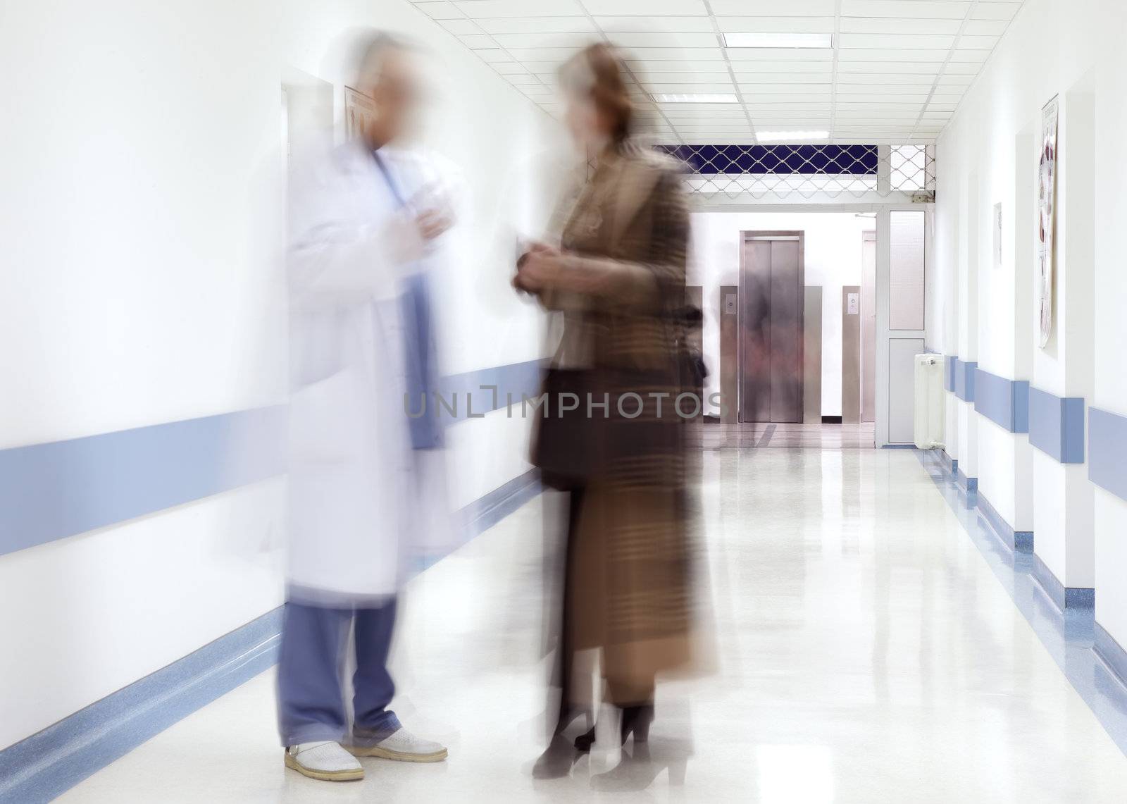 blurred figures of doctor and patient in a hospital corridor