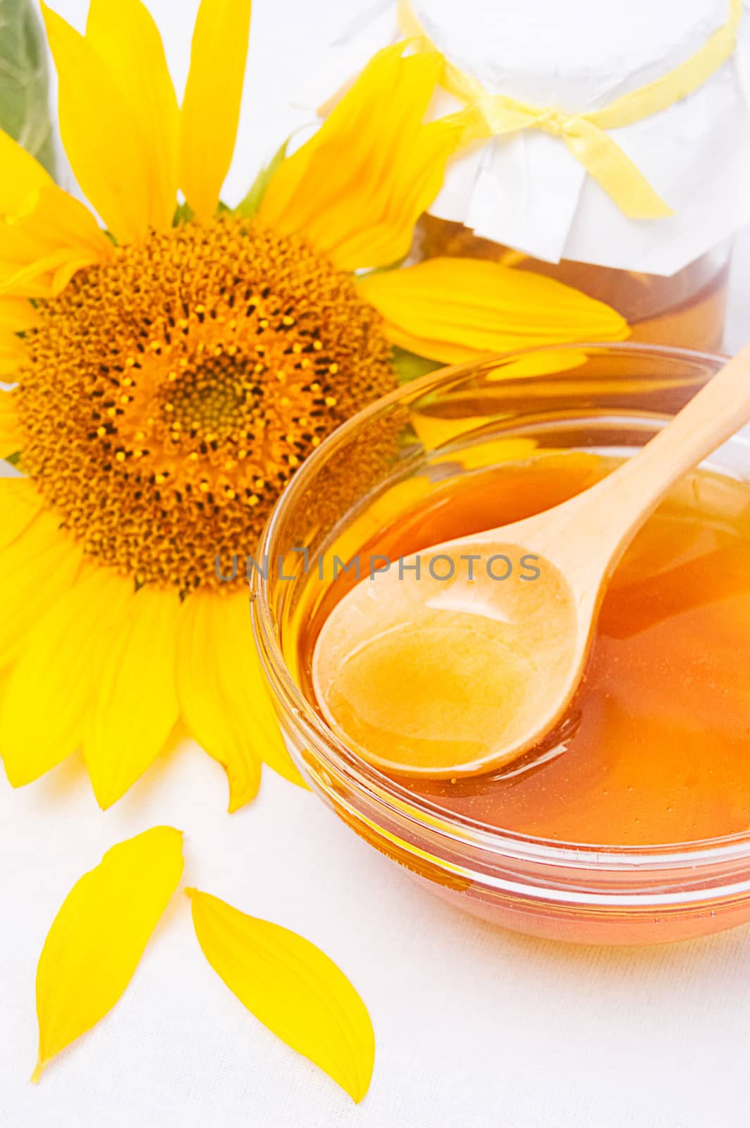 Honey in jar with wooden spoon and sunflower