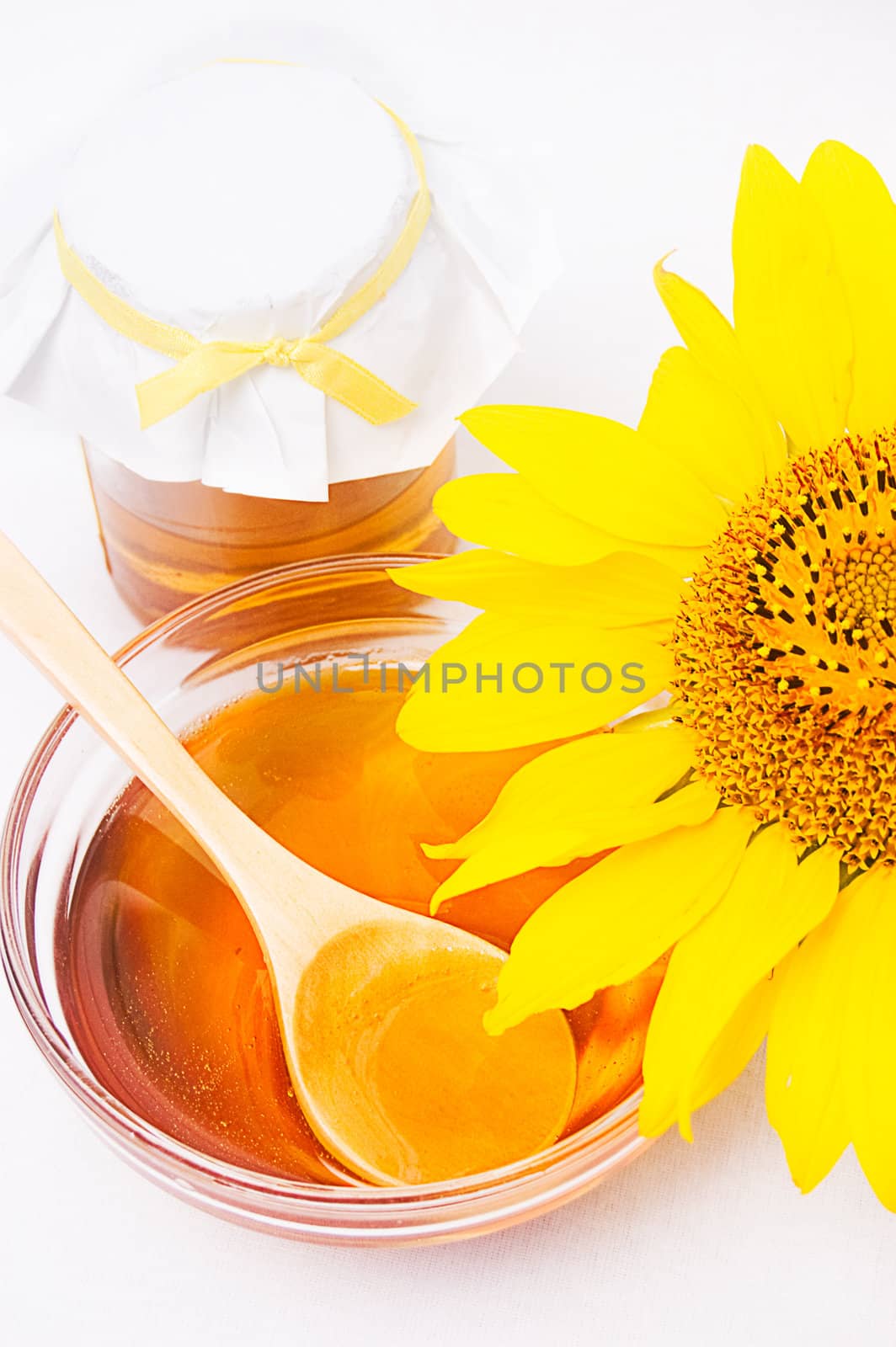 Honey in jar with wooden spoon and sunflower