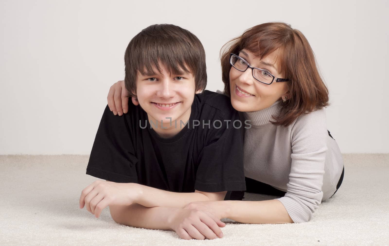 mother and son are together and smile in studio