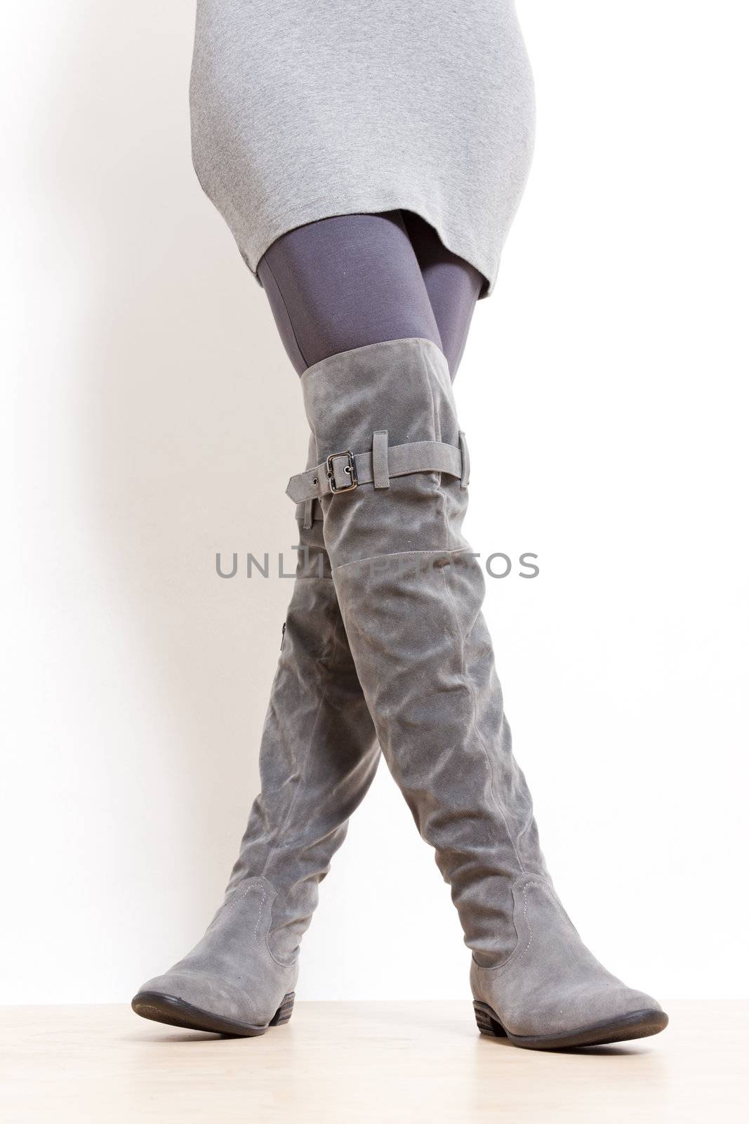 detail of standing woman wearing fashionable gray boots