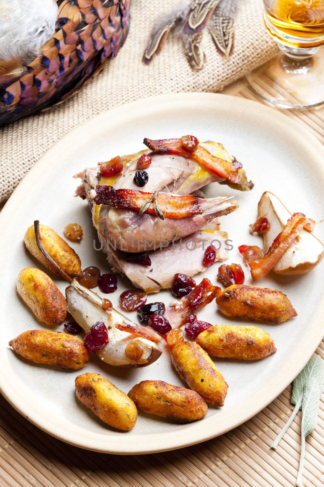 baked pheasant with bacon, pear, raisins on brandy