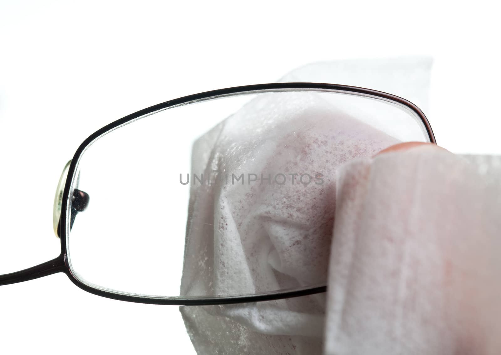 Macro image of a soft white cloth cleaning the lens of a pair of spectacles