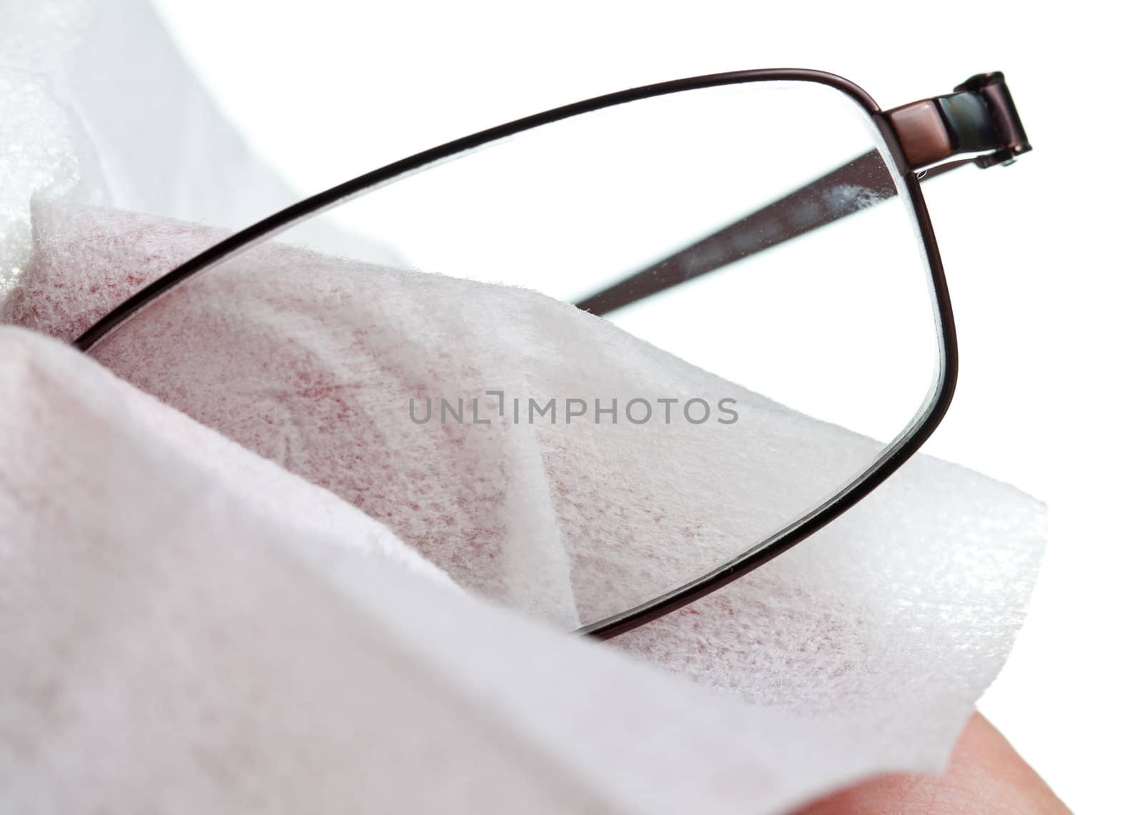 Macro image of a soft white cloth cleaning the lens of a pair of spectacles