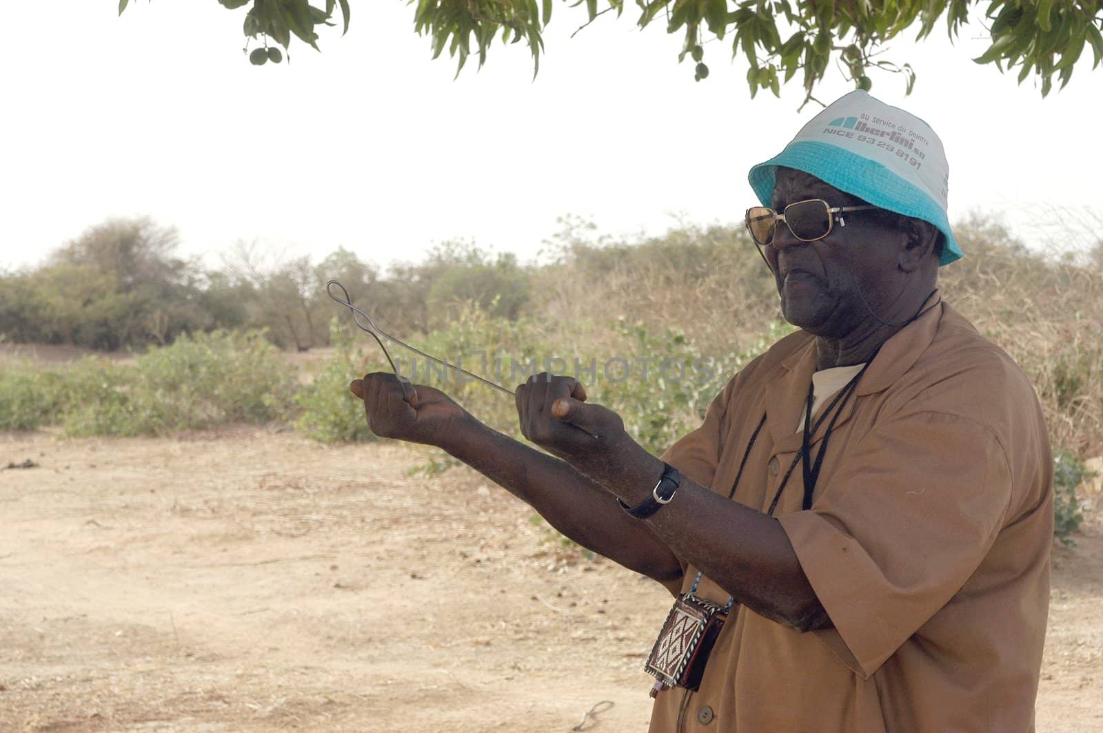 African waterfinder with work in an area of Burkina Faso Faso. Water is not rare in Africa, only it is necessary to drill wells to reach it. The waterfinder thus determines the place exact where to drill because drilling costs 8000 ? and it is not question of missing the place where the machines will have to work.