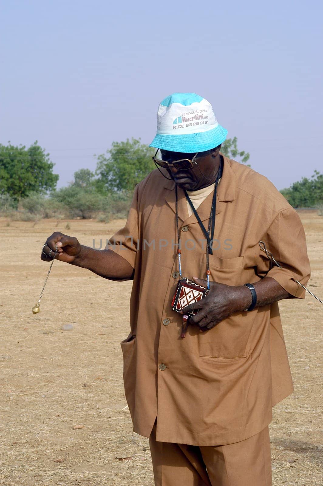 African waterfinder with work in an area of Burkina Faso Faso. Water is not rare in Africa, only it is necessary to drill wells to reach it. The waterfinder thus determines the place exact where to drill because drilling costs 8000 ? and it is not question of missing the place where the machines will have to work.
