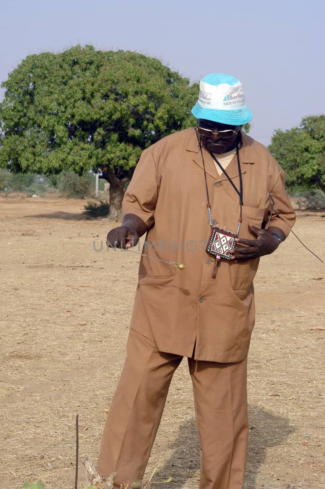 African waterfinder with work in an area of Burkina Faso Faso. Water is not rare in Africa, only it is necessary to drill wells to reach it. The waterfinder thus determines the place exact where to drill because drilling costs 8000 ? and it is not question of missing the place where the machines will have to work.