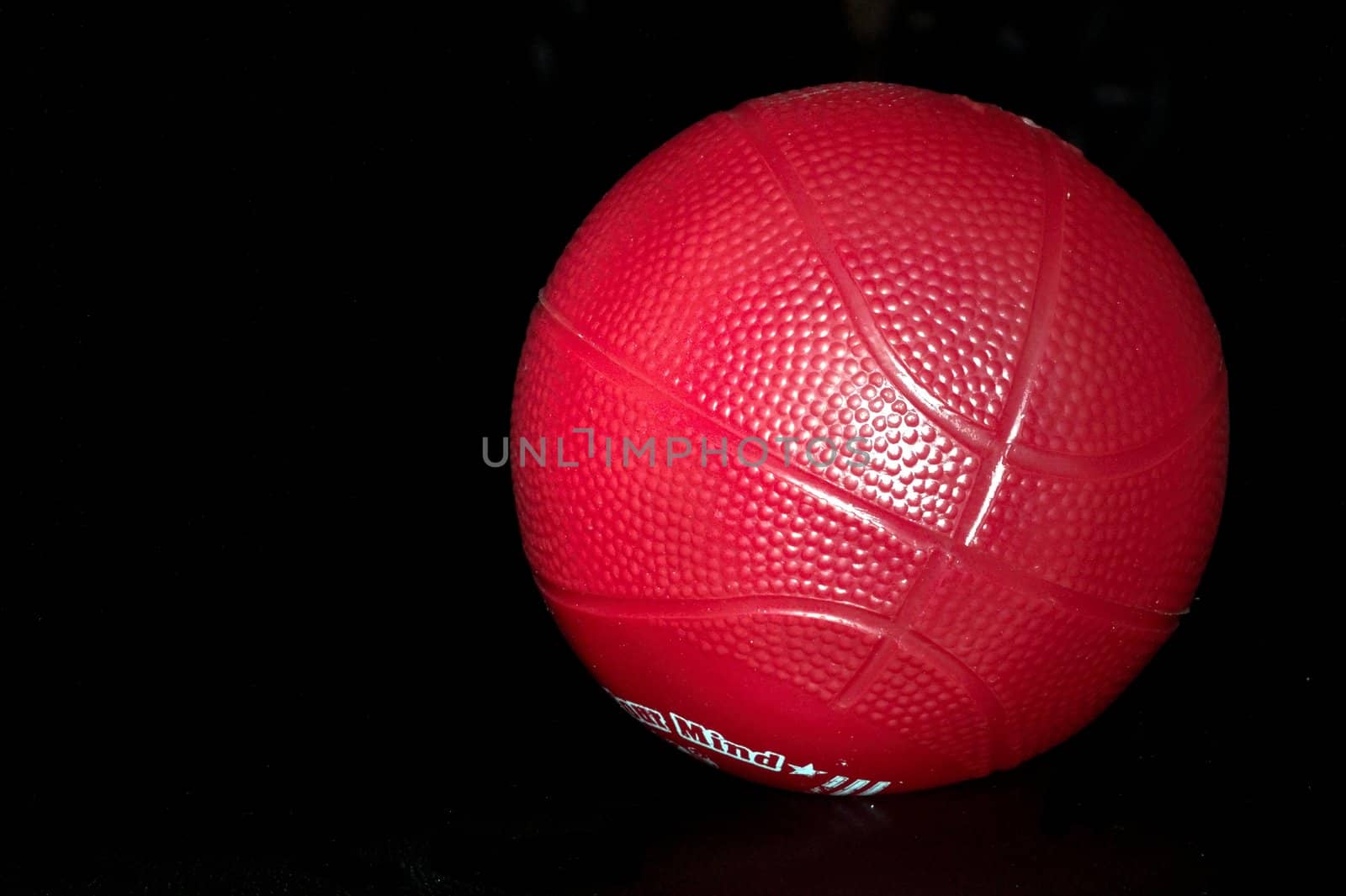 red toy basketball on black background