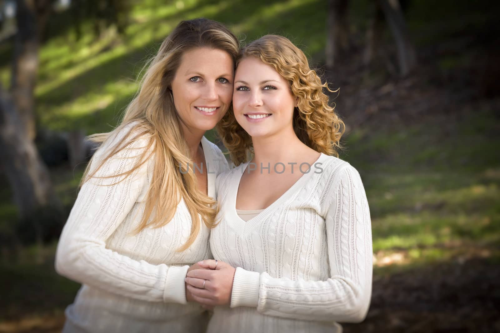 Pretty Mother and Daughter Portrait Hugging in the Park on a Fall Day.