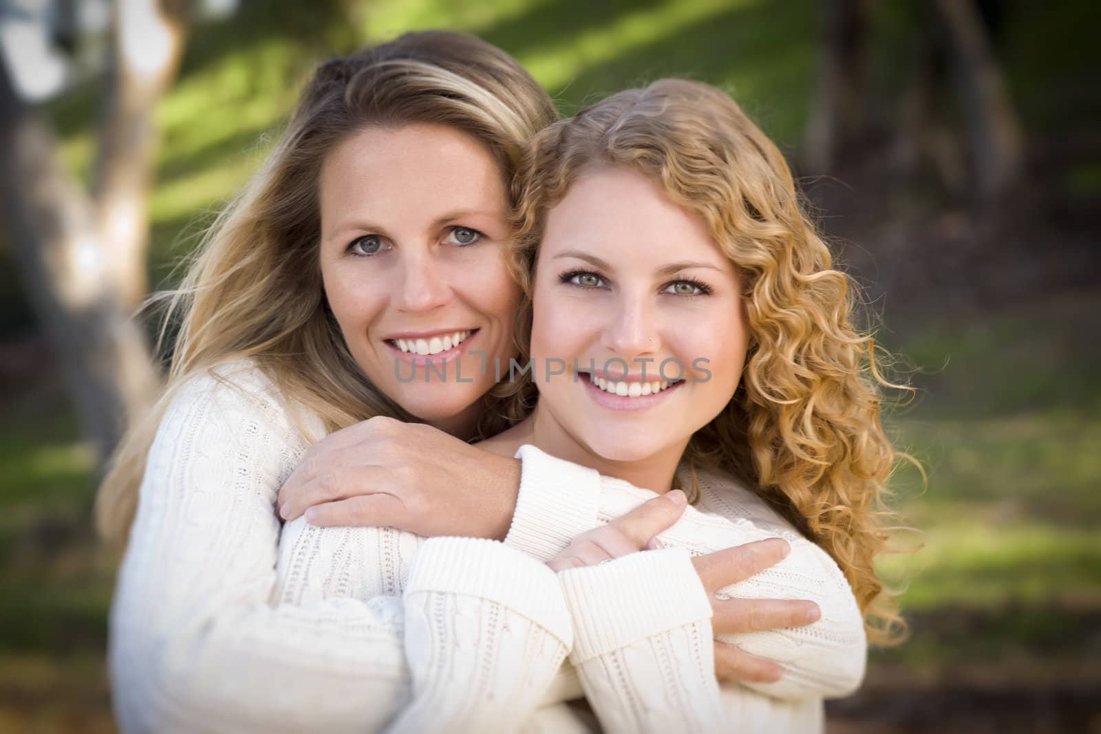 Pretty Mother and Daughter Portrait Hugging in the Park on a Fall Day.