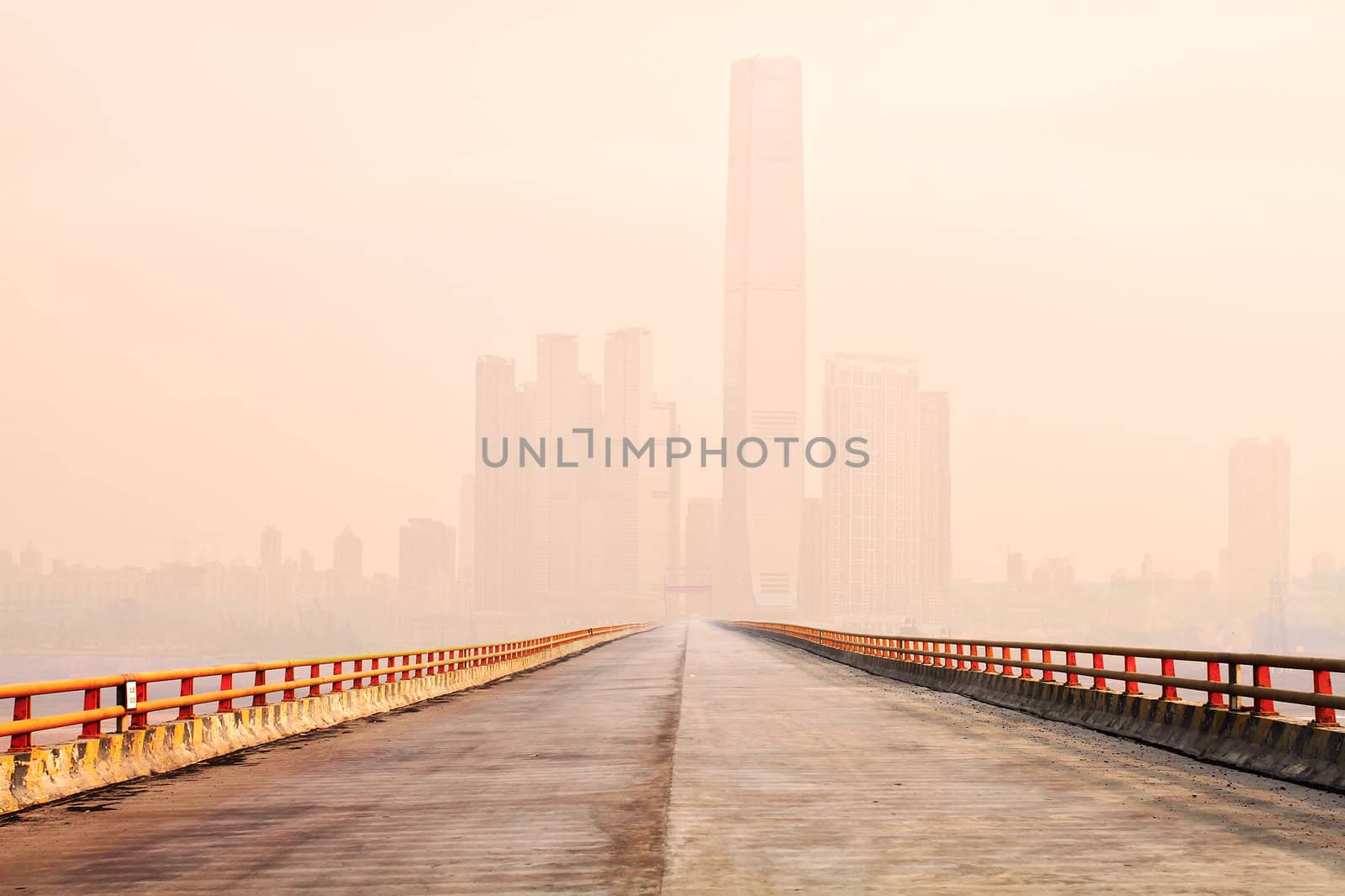 Photo of a bridge leading to the downtown of an international modern city in the fog morning