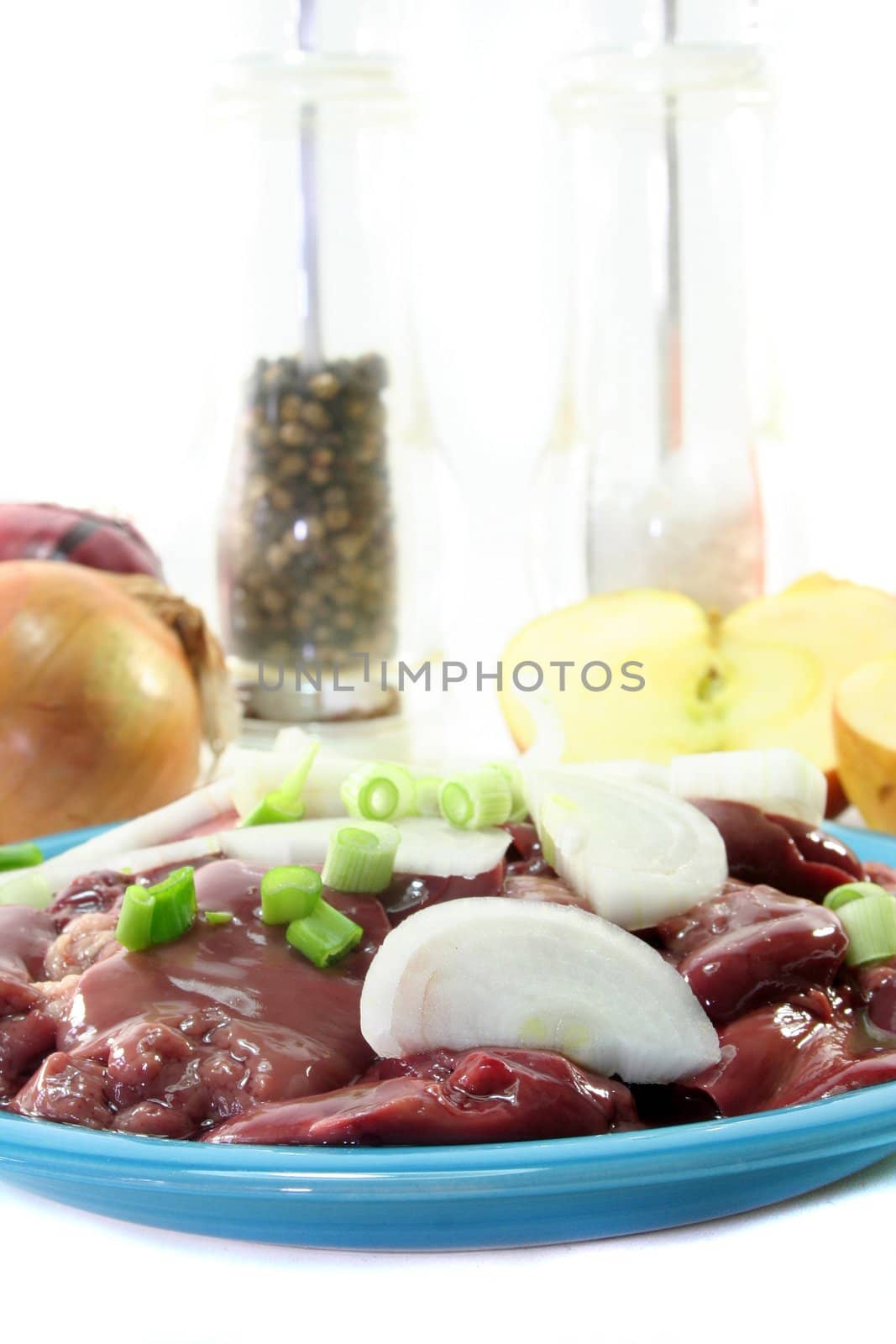 raw liver with onions on a blue plate