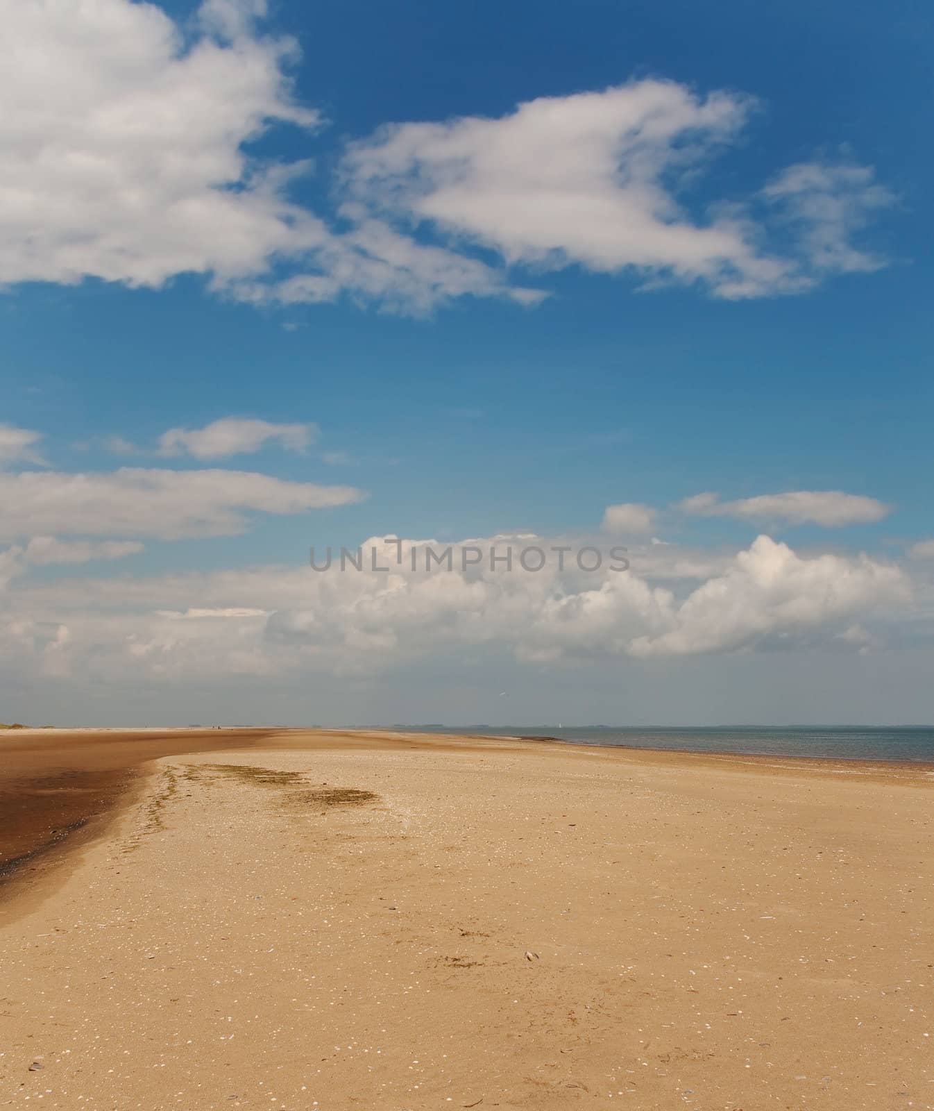outdoor photo of an empty beach under a blue sky