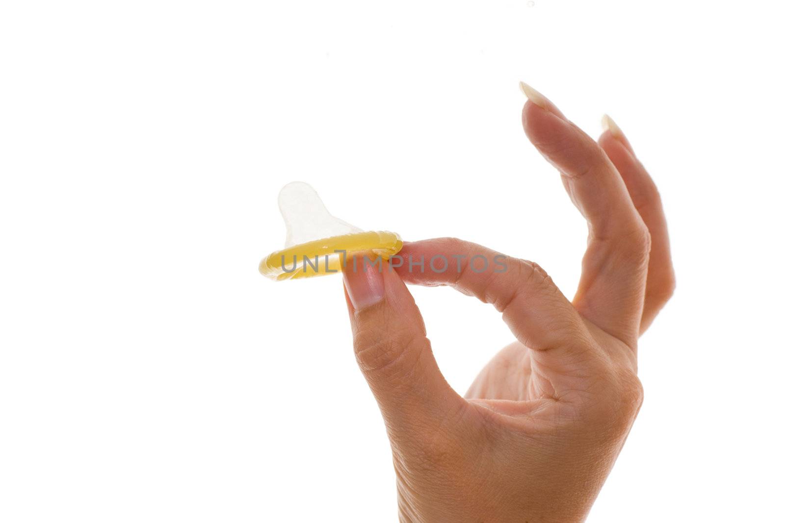 Studio photo of a womans hand holding a condom