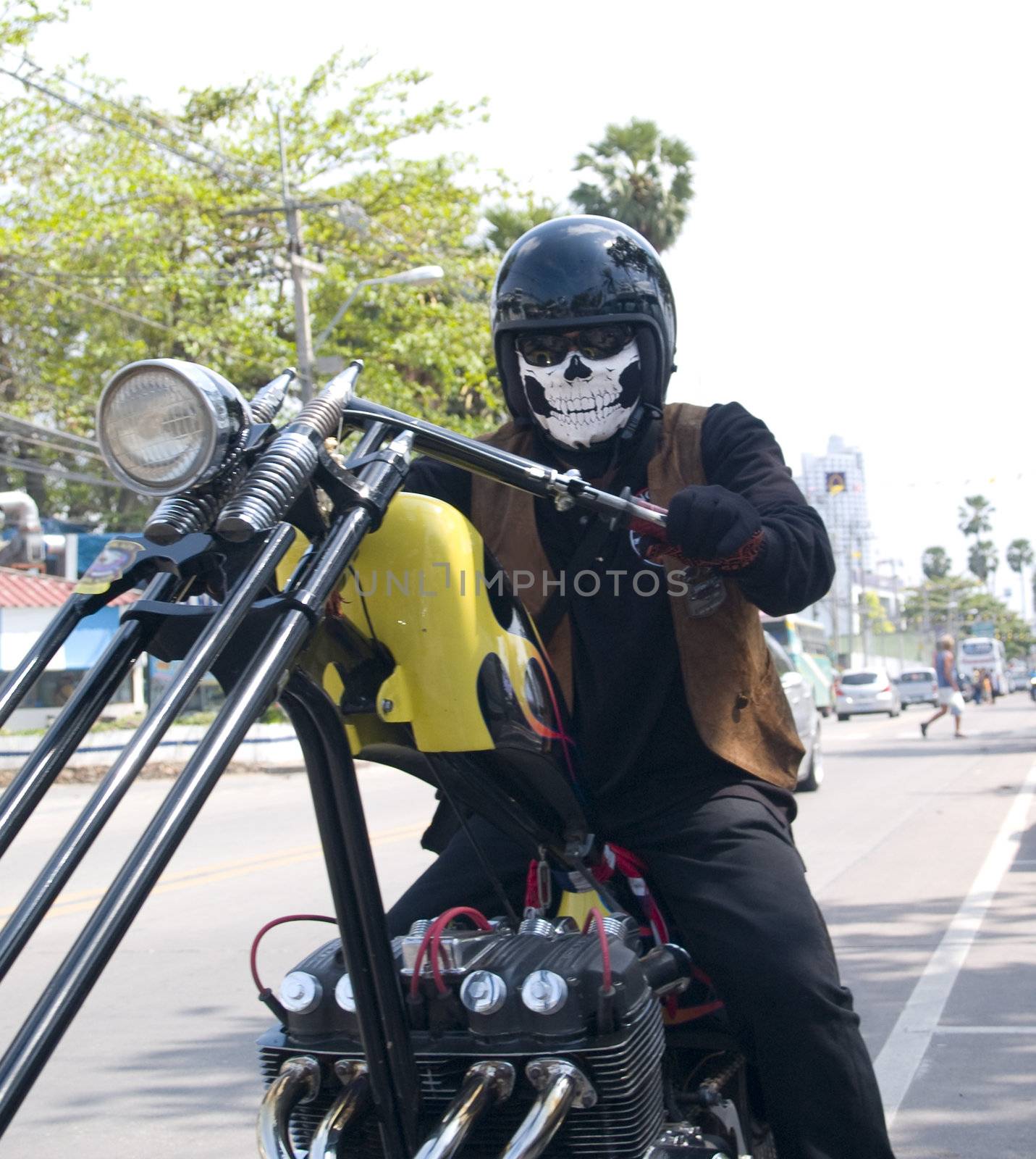 Motorcycle rider on a custom built chopper with scary mask resembling a skull