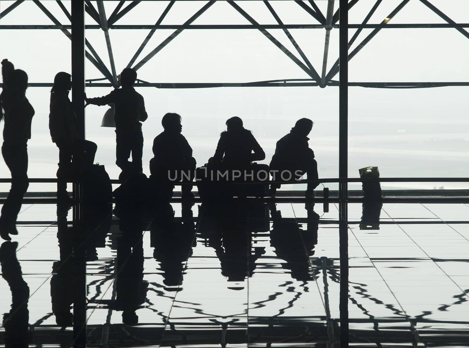 Silhouettes and reflections of passenger waiting at an airport
