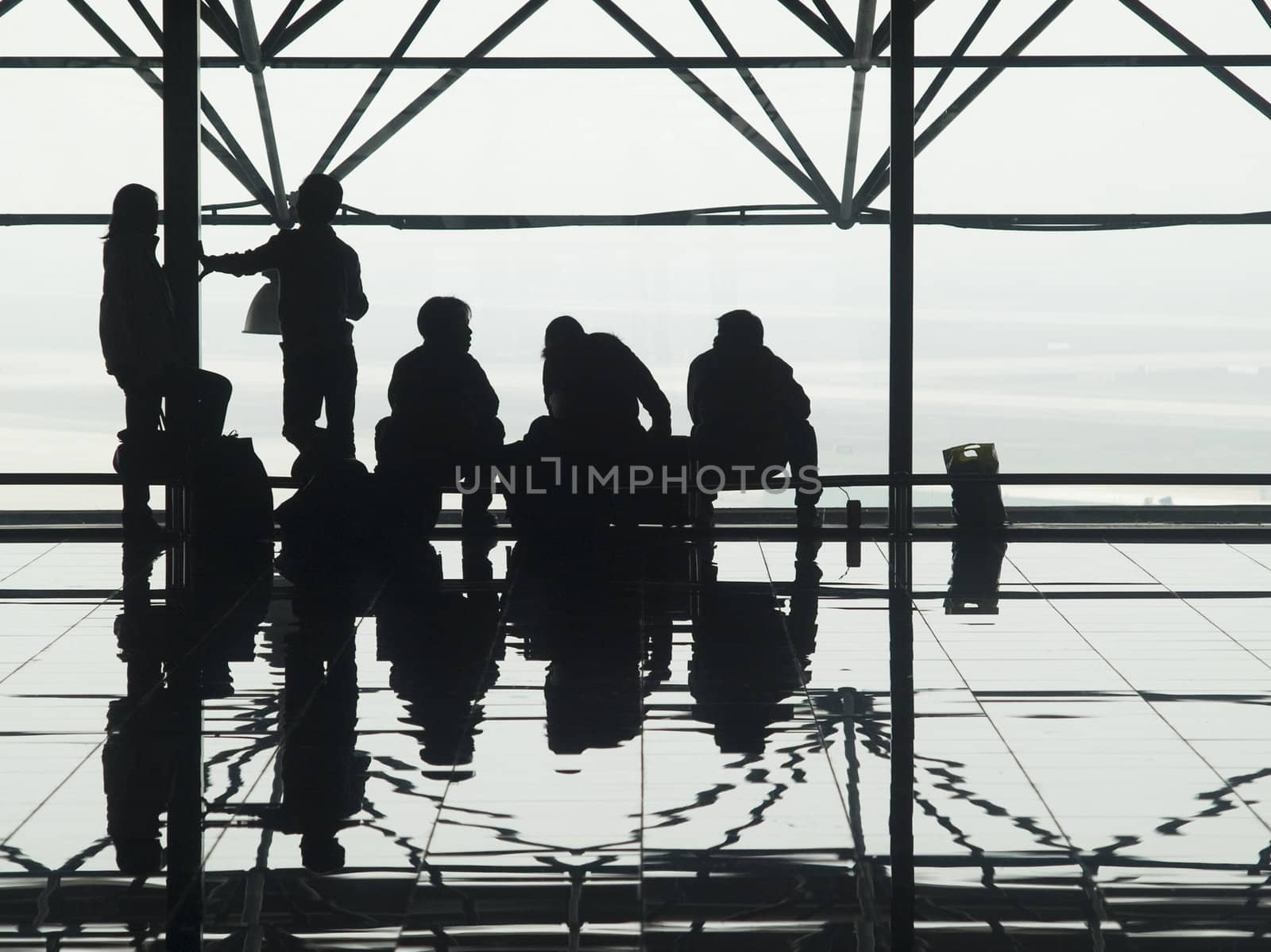 Silhouettes and reflections of passenger waiting at an airport