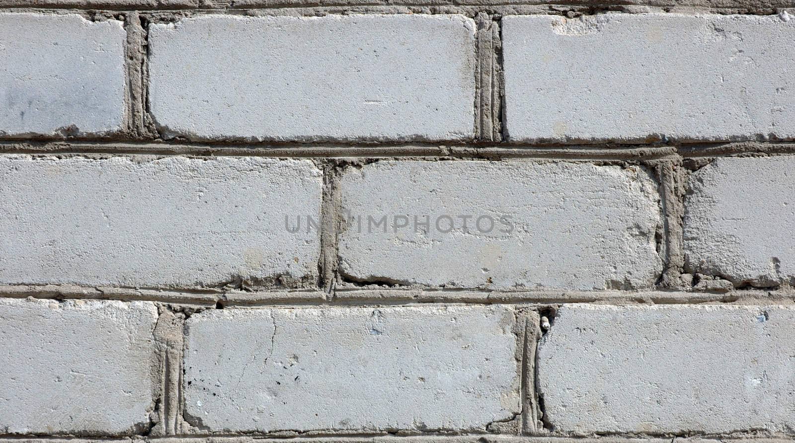 Old gray brick wall. White (in past) silicate bricks like background.