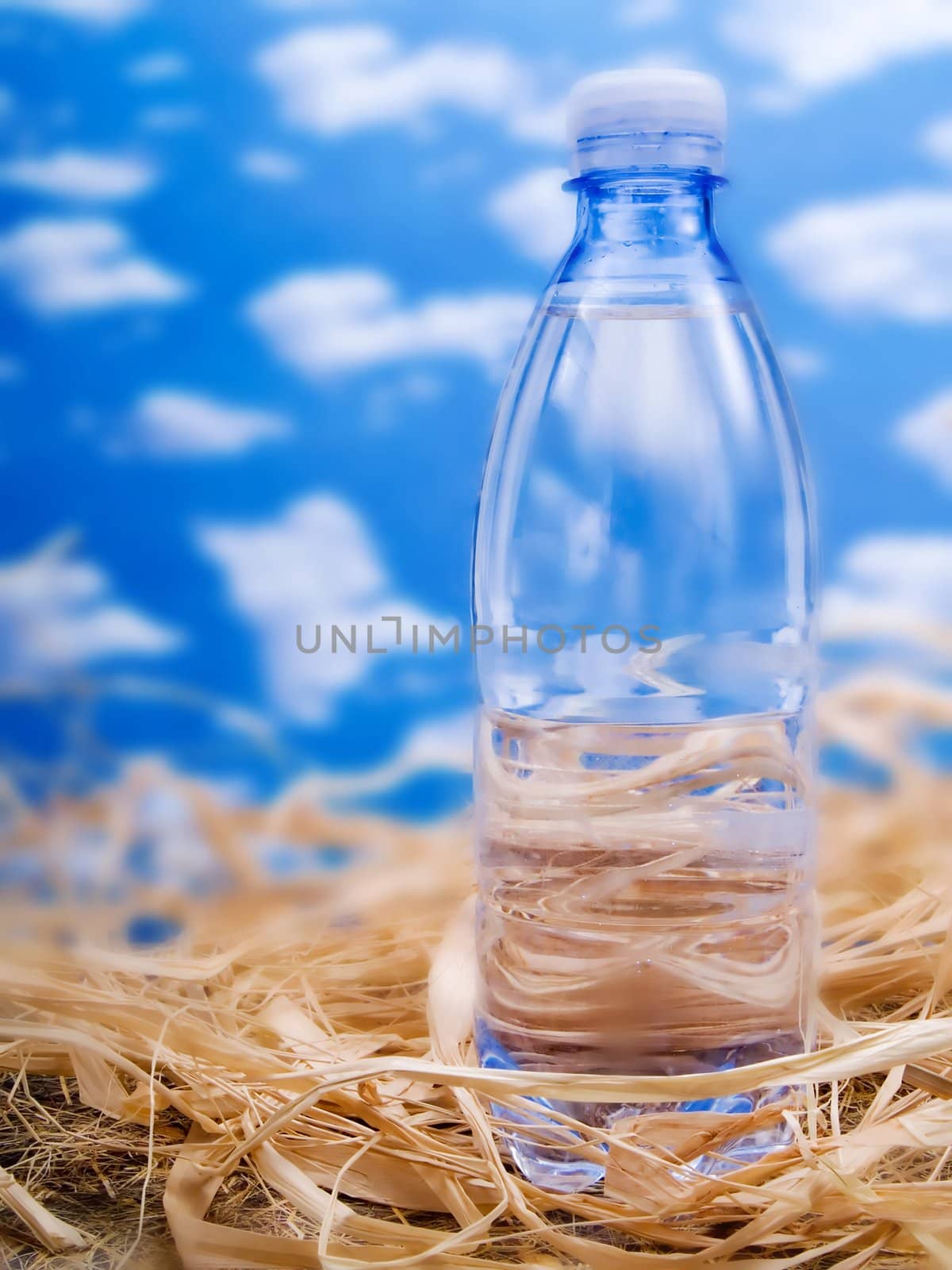 Bottle of mineral water over a blue sky