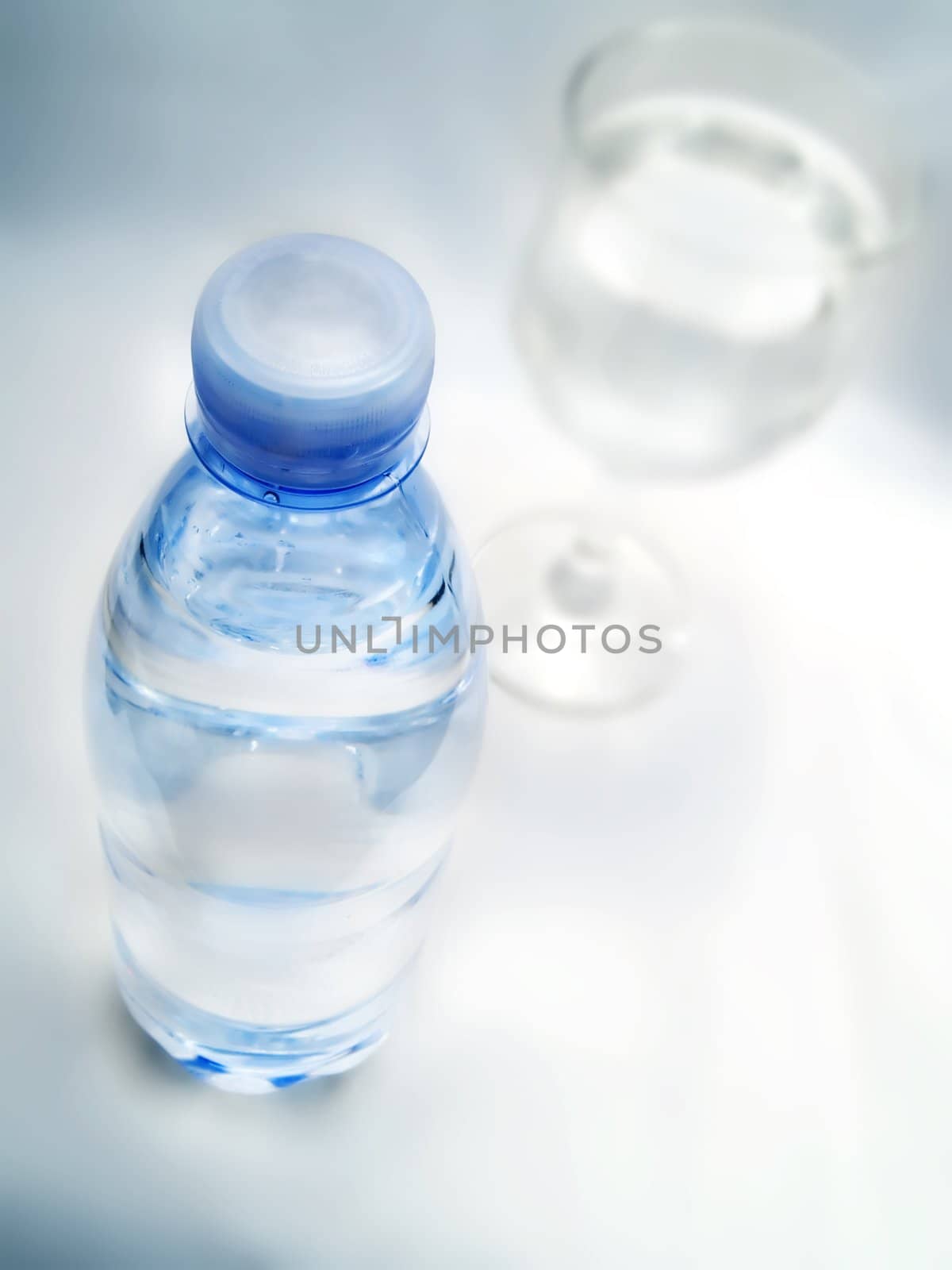 Bottle of water and glass on a white background