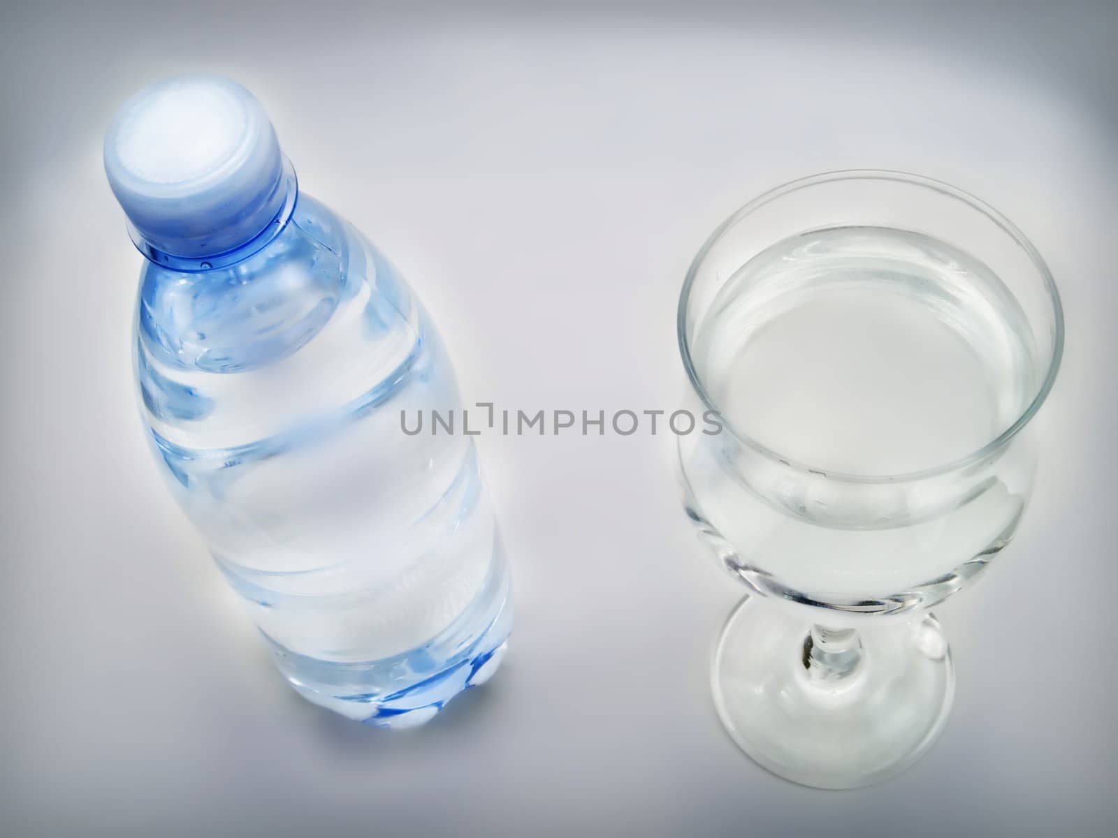 Bottle of water and glass on a white background