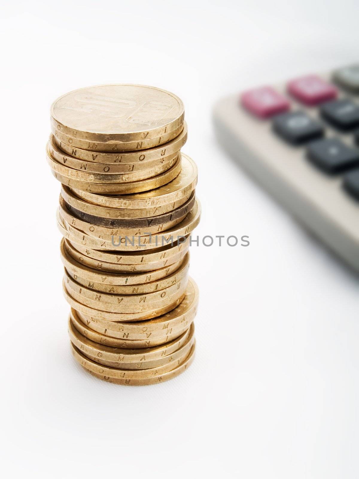 Pile of coins and  calculator on a white background