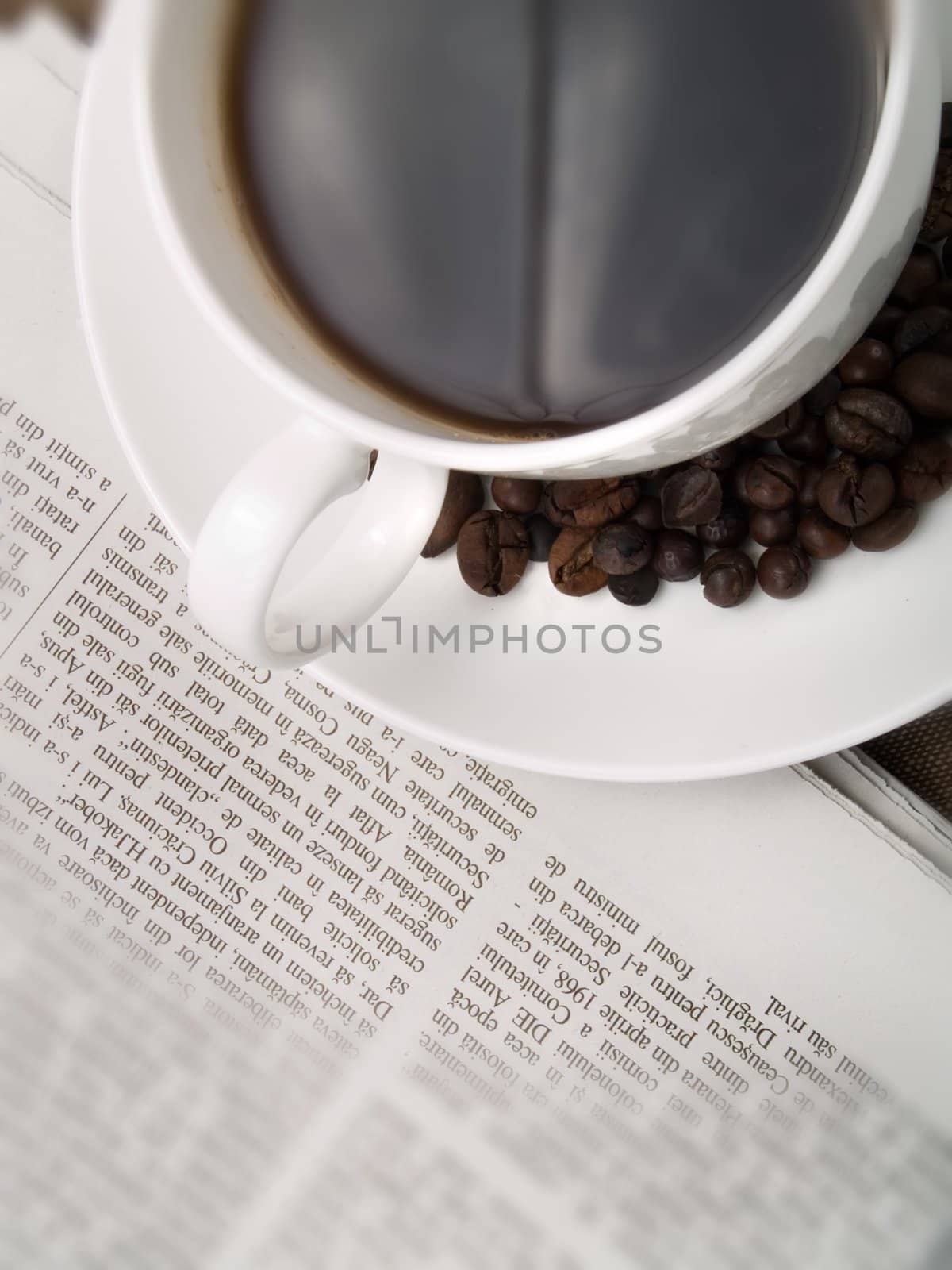 Coffee cup with coffee beans and a newspaper