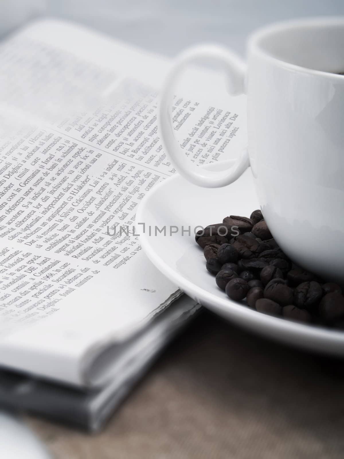 Coffee cup with coffee beans and a newspaper