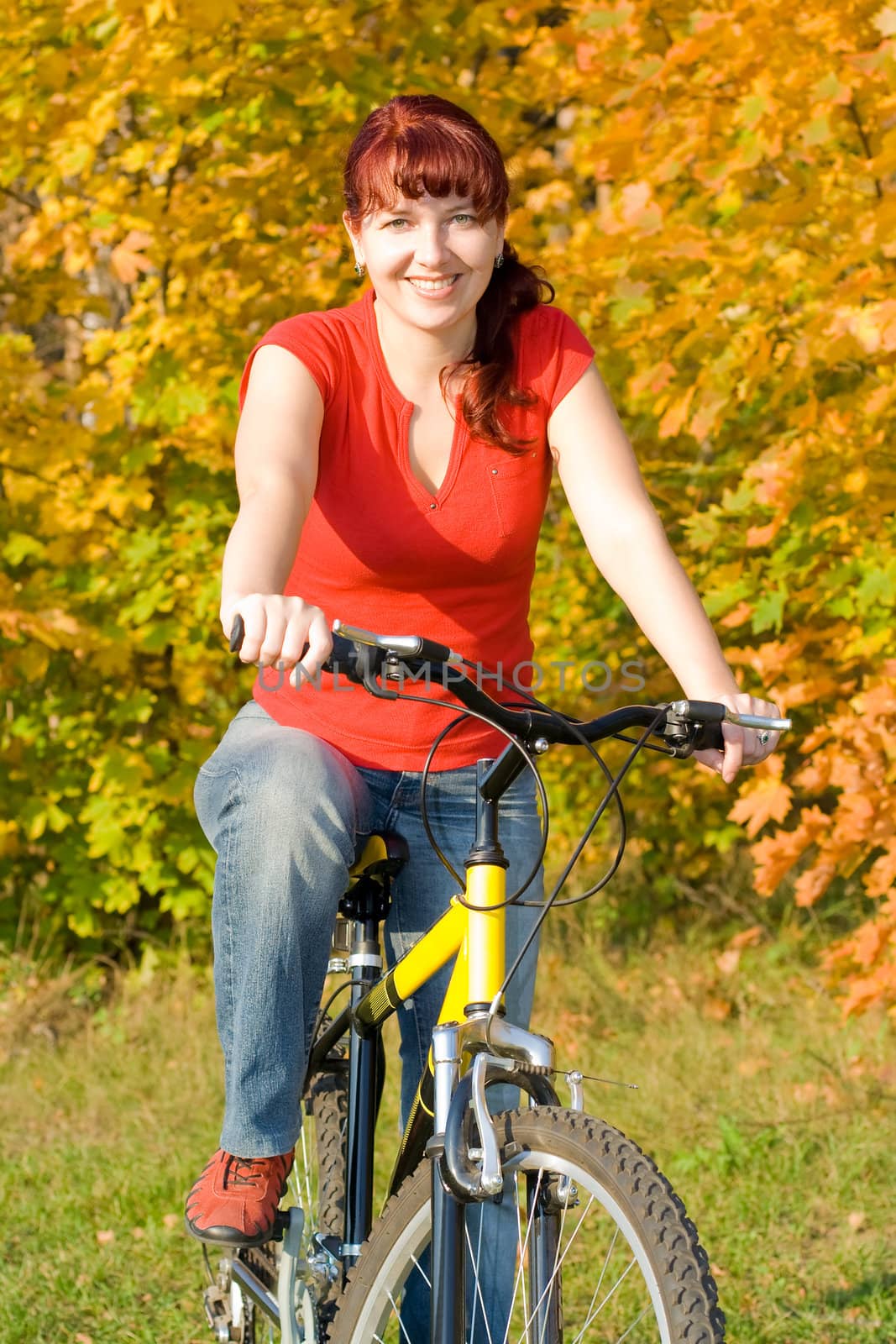 Young beautiful happy women on her bicycle in the fall