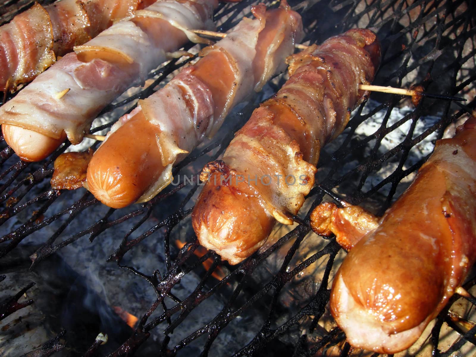 Sausage in bacon over grill