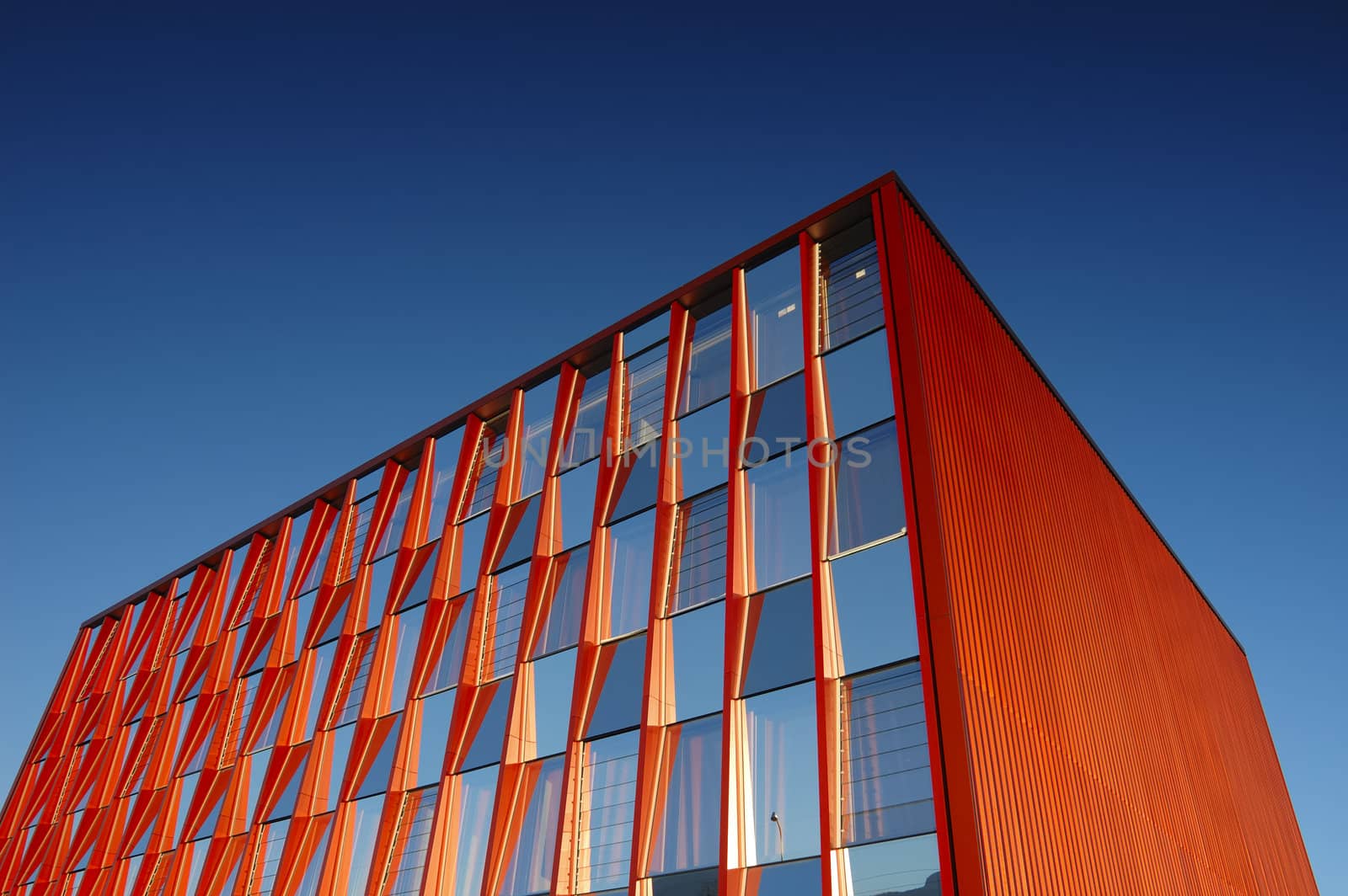 An orange office block standing out strongly against a clear blue sky