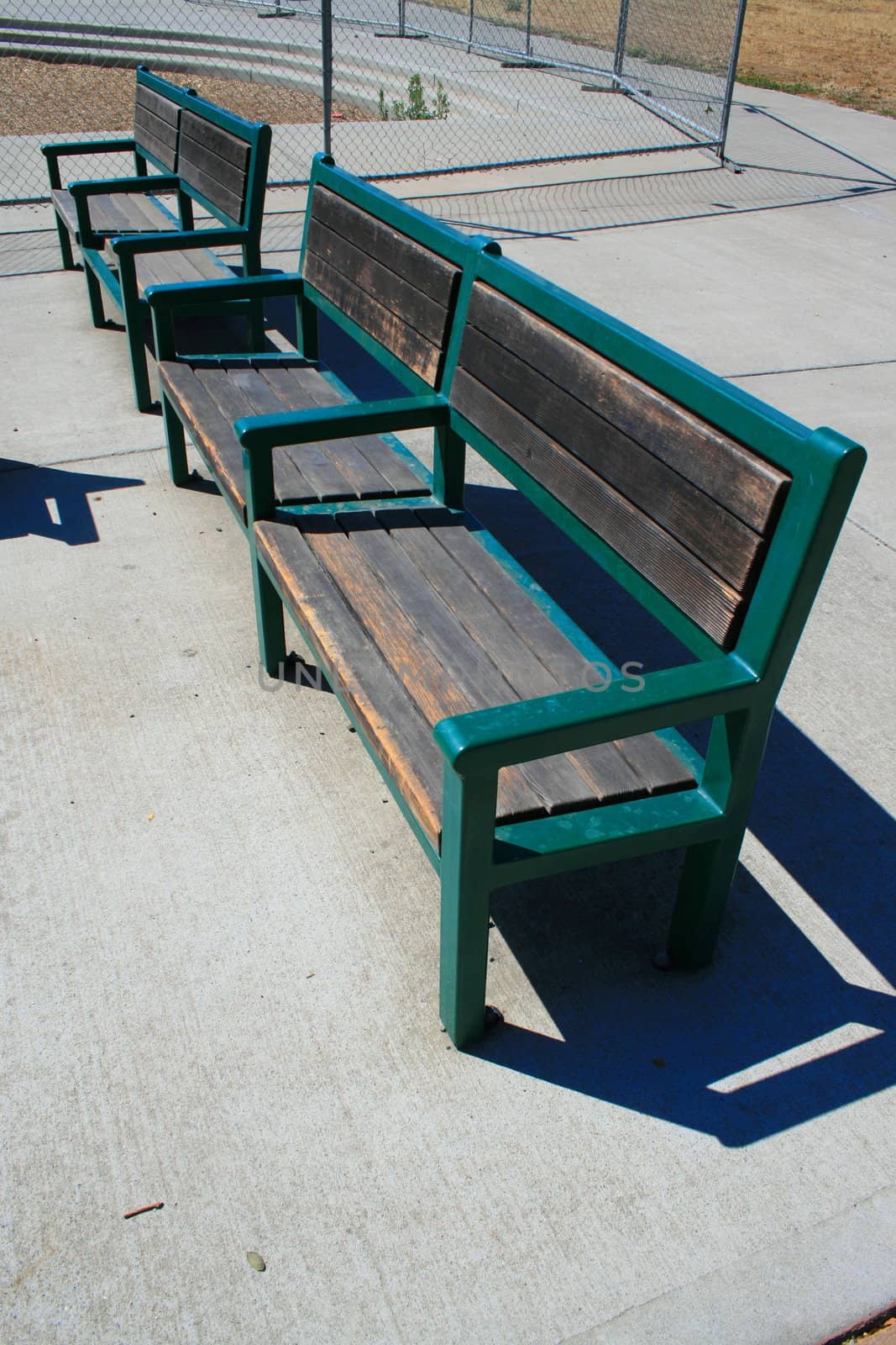 Close up of the two green benches in a park.