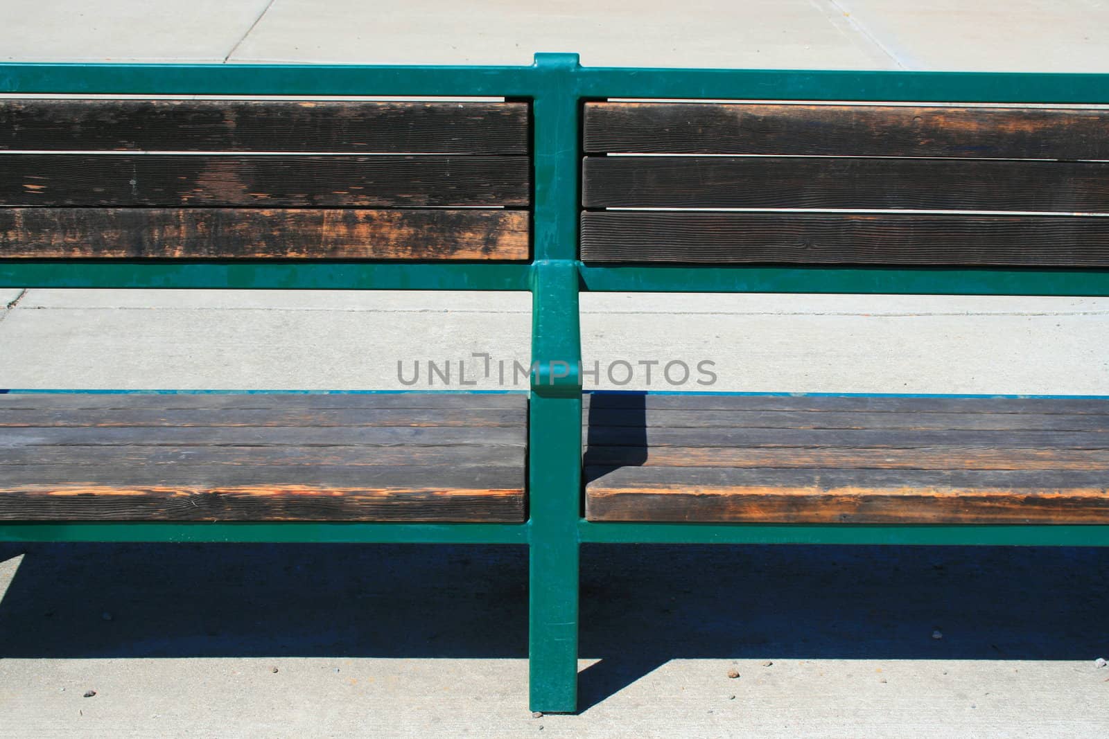 Close up of a green bench in a park.
