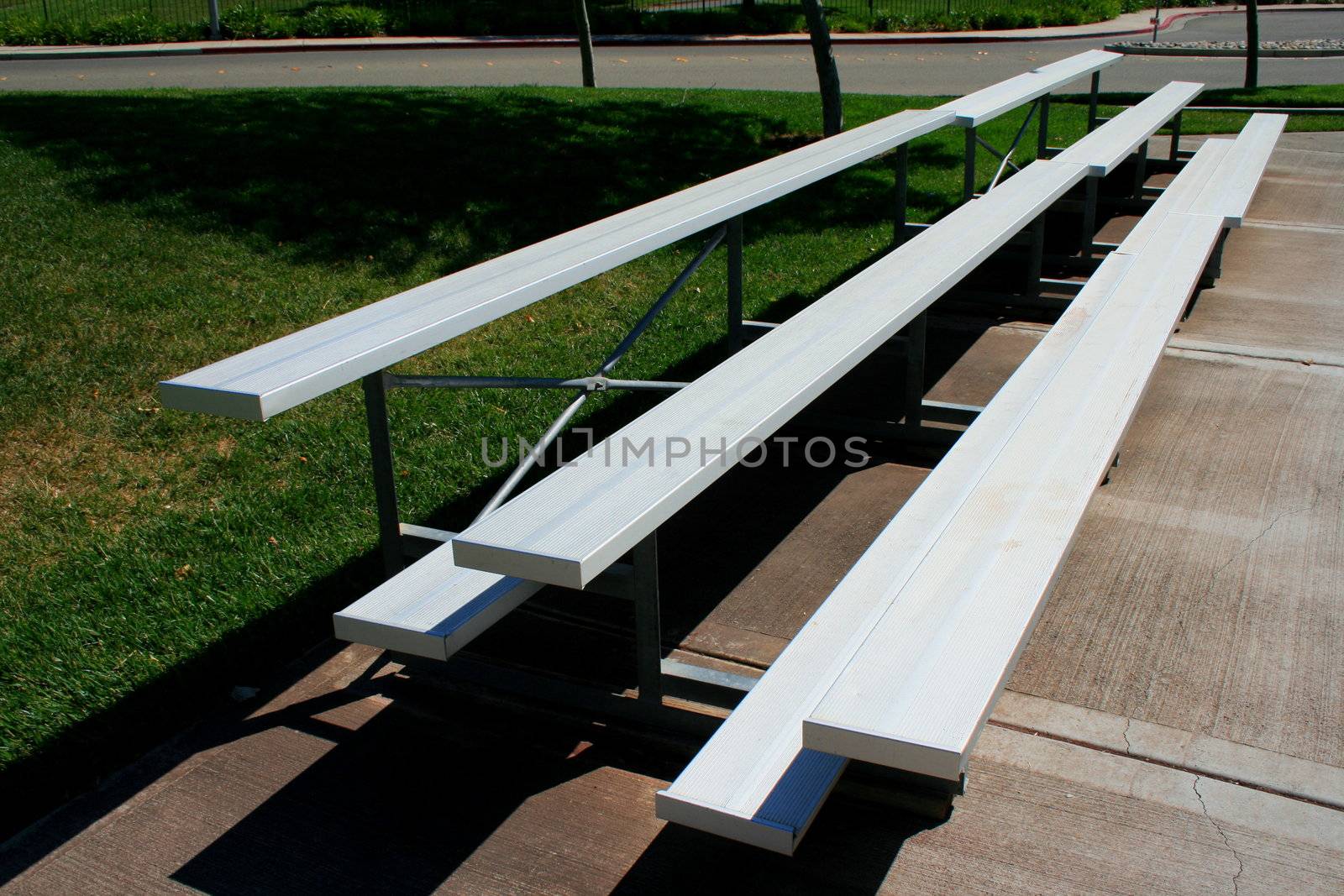 Empty bleachers on a stadium in a park.
