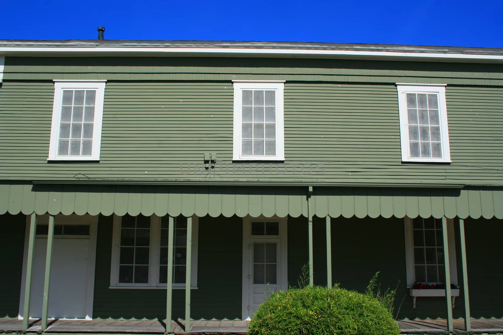 Close up of a green wooden building.
