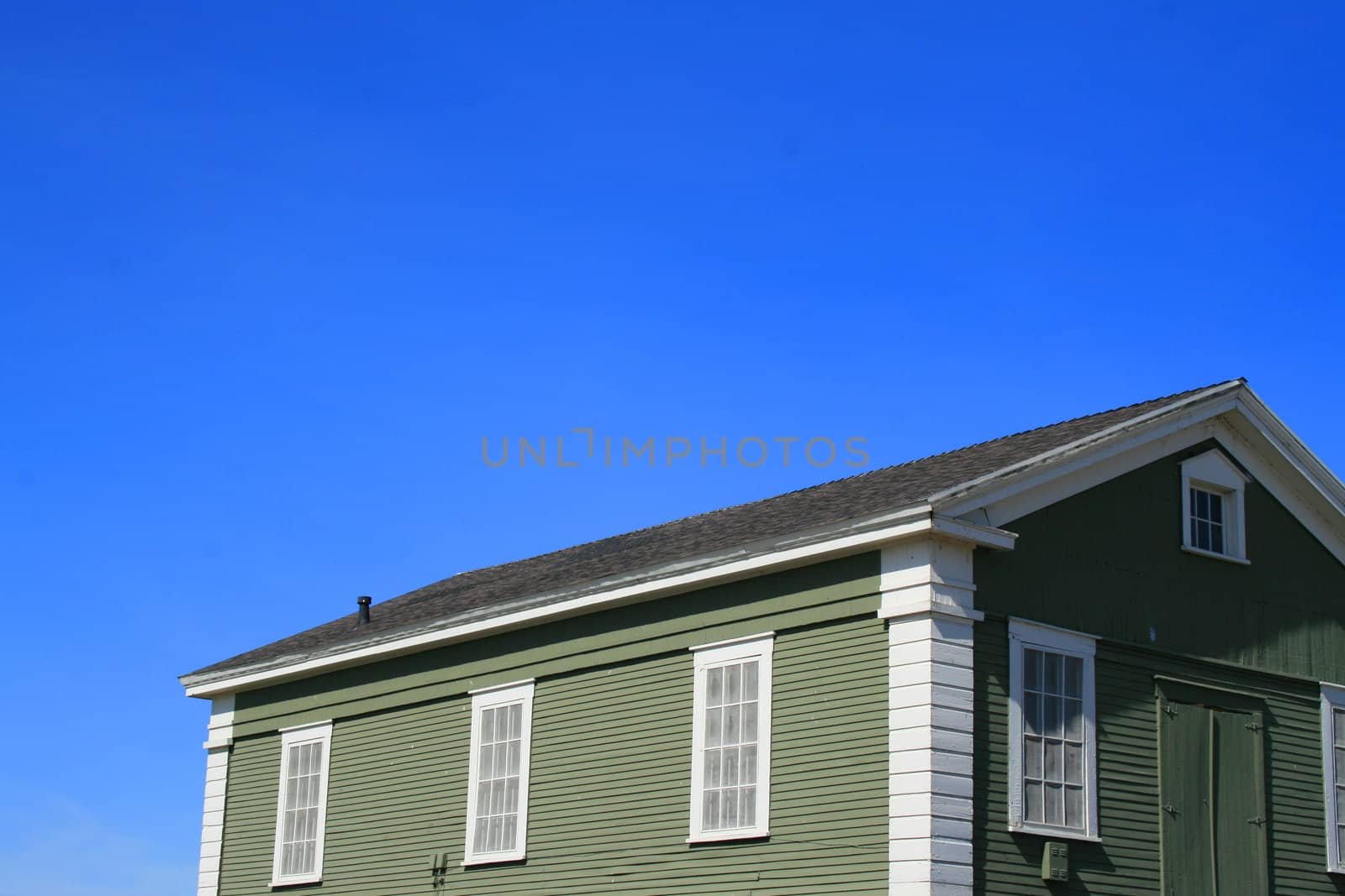 Close up of a green wooden building.
