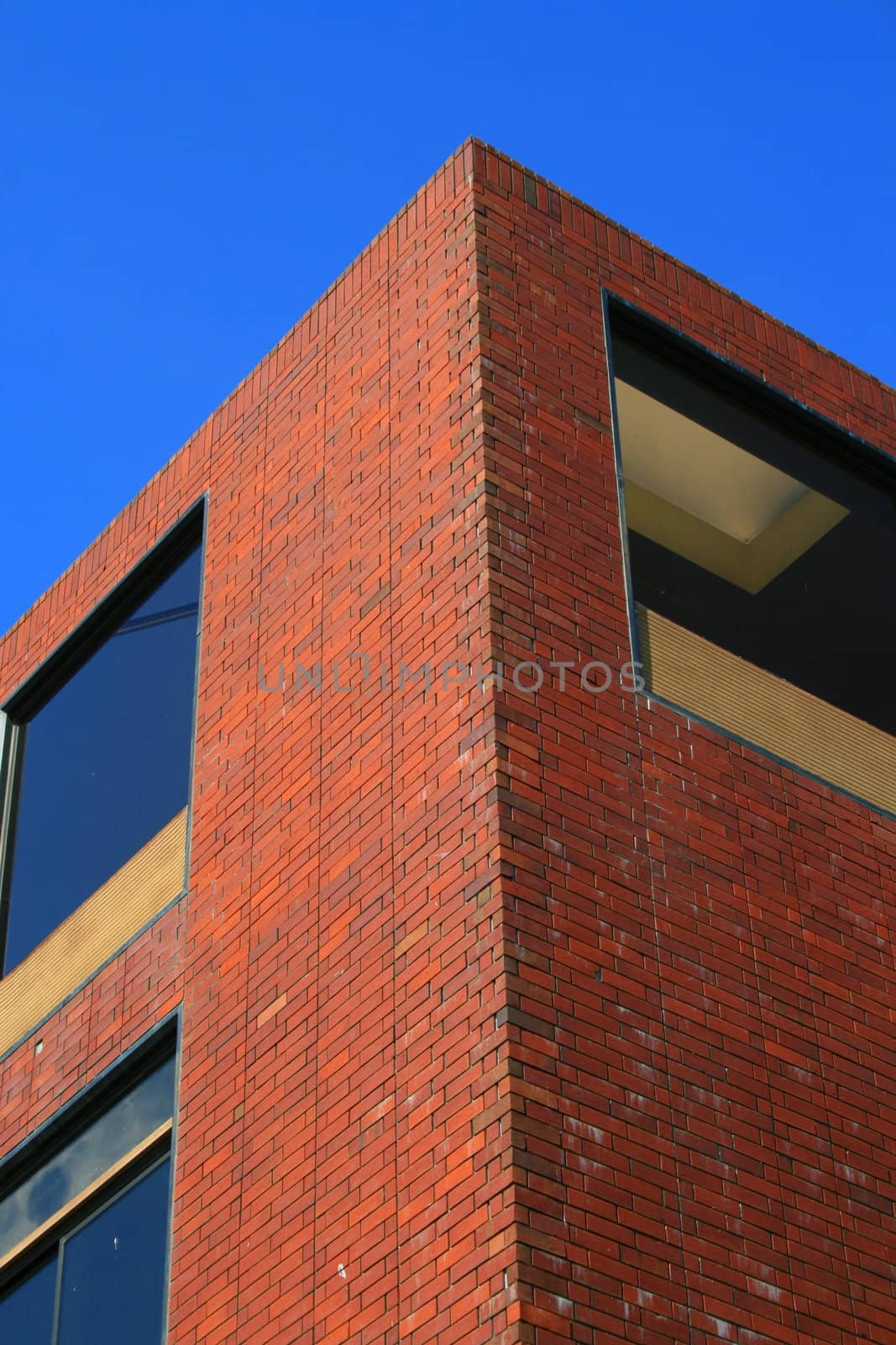 Corner of a brick building over blue sky.
