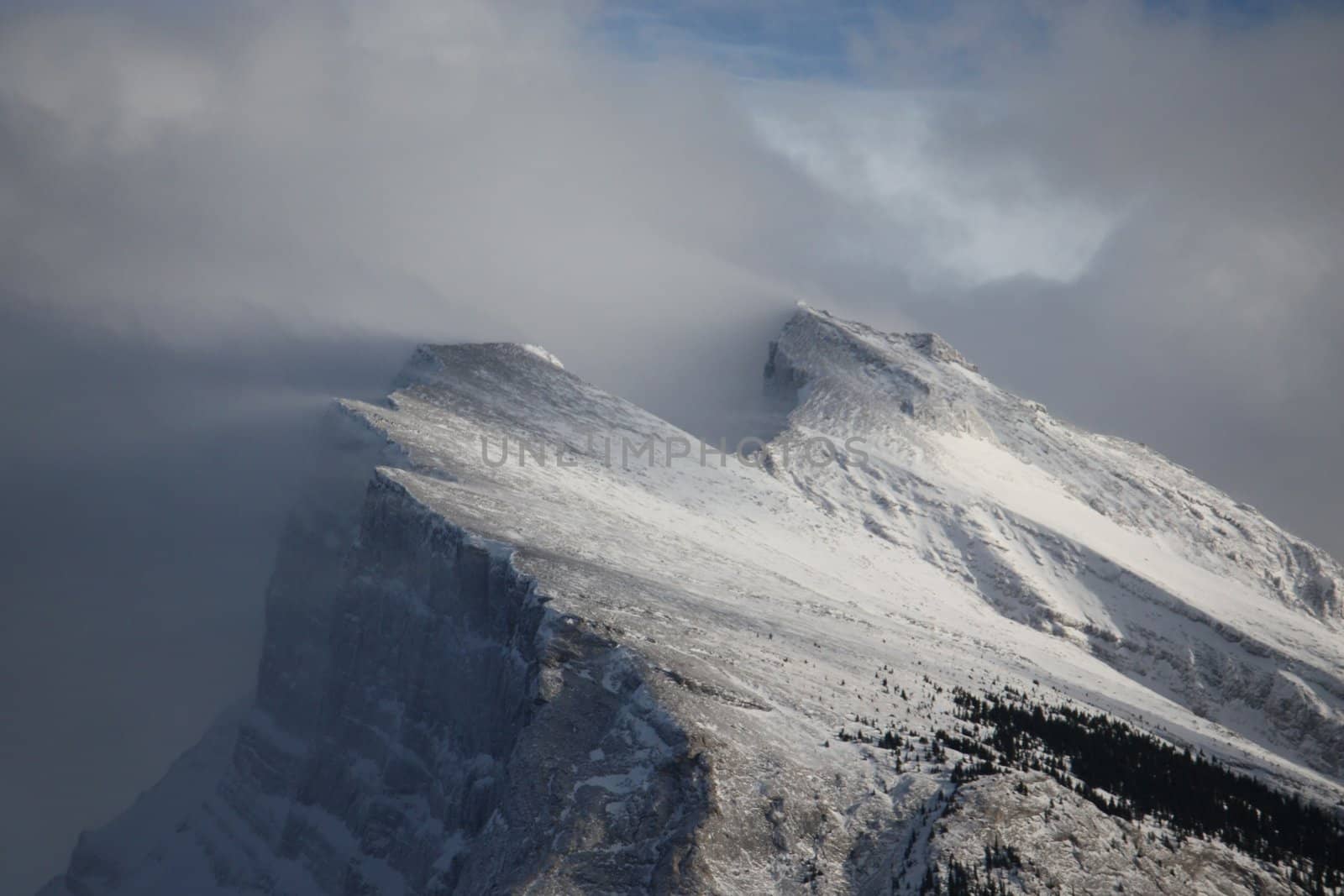 Snow streaming off a mountain top