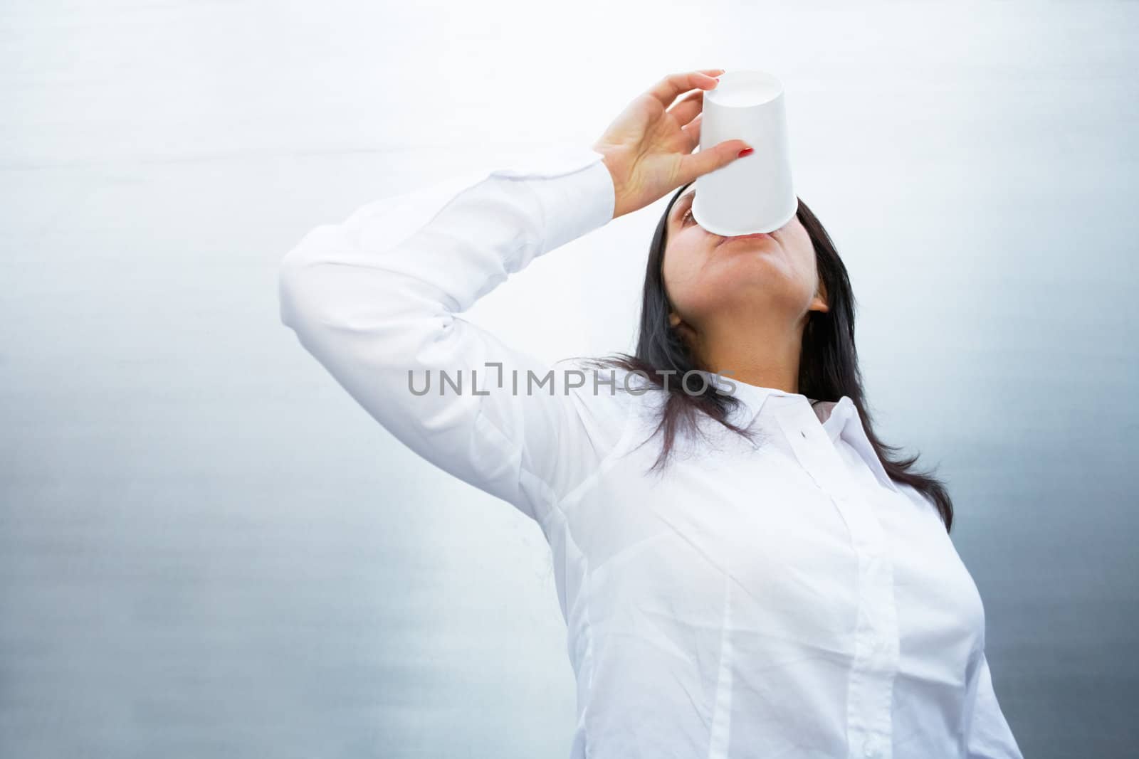 Young woman drinking coffee outside building